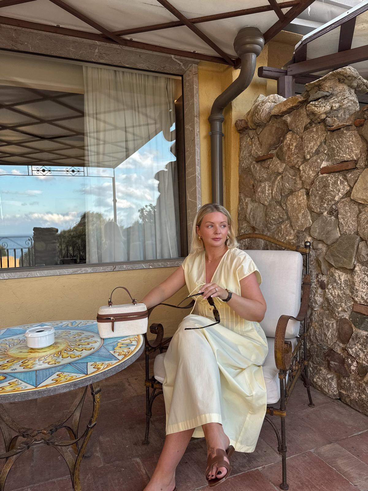 Summer holiday butter yellow dress outfit idea. Wat the brand butter yellow dress, Monica vinader gold snake chain necklace & Missoma gold chunky hoop earrings, canvas & tan small handbag, tan brown Hermes Oran sandals

#LTKsummer #LTKuk #LTKstyletip