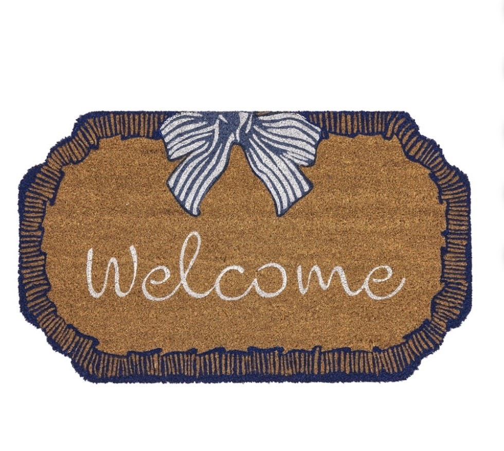 The My Texas House Bow Welcome Coir Outdoor Doormat offers a touch of classic charm to your front entryway. This beautifully designed mat features the word "Welcome" in a graceful white script, creating an immediate sense of warmth for visiting friends and family. Above the greeting, a classic blue and white striped bow adds a refined, decorative detail that feels both timeless and inviting. The entire design is framed by a sophisticated dark blue scalloped border, providing an effortlessly stylish look that enhances your doorstep. Measuring 48 inches by 30 inches, it's a practical and beautiful addition to your home. Elevate your home's first impression and greet your guests in style with the My Texas House Bow Welcome Coir Outdoor Doormat.

#LTKmorningroutine #LTKHome #LTKSeasonal