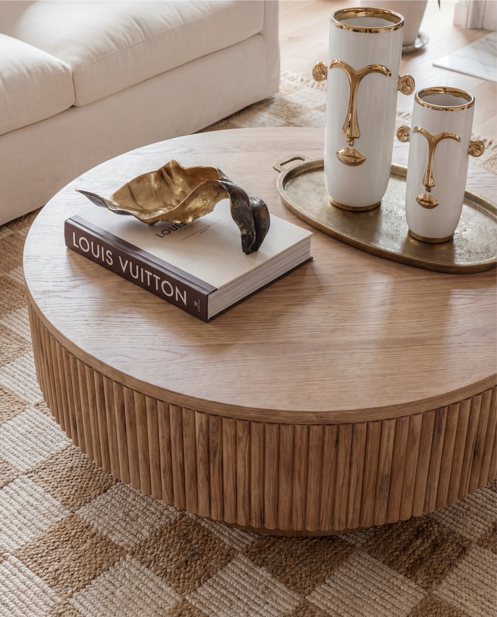 Shop the Look:
• Cream upholstered sofa
• Cream upholstered armchairs
• Round fluted wood coffee table
• Light wood side tables
• Neutral woven area rug (beige + ivory)
• Knitted pouf ottomans (natural tone)
• White globe pendant light with brass hardware
• Exposed wood ceiling beams
• Black arched window frames
• Sheer white curtain panels
• Marble fireplace surround
• Gold framed wall mirror (vintage style)
• Ceramic decorative vases (white + neutral)
• Brass decorative tray
• Sculptural brass bowl
• Coffee table books (fashion or design)
• Indoor potted tree (fiddle leaf fig or olive)
• Light wood flooring
• Neutral throw blanket (textured knit)


#LTKHome #LTKSaleAlert