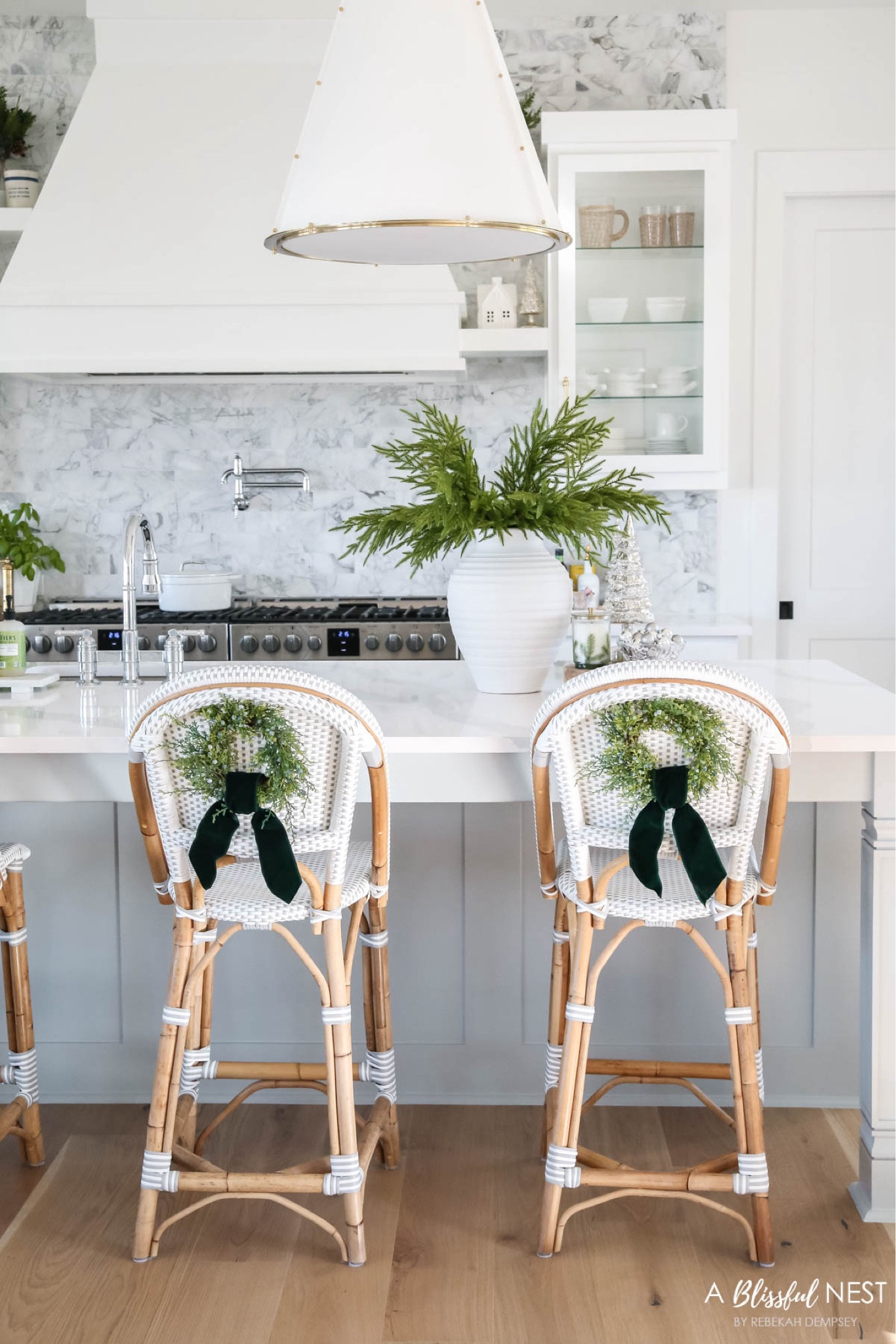 A peek at my holiday kitchen!
Includes the viral Norfolk pine stems, mini wreaths for my barstools with thick green velvet ribbon, Serena & lily barstools, tall white vase, Fraser fir candle. 

Holiday home tour, Christmas home tour, Christmas kitchen, coastal holiday decor, coastal style, coastal grandmother


#LTKHome #LTKHoliday #LTKSeasonal