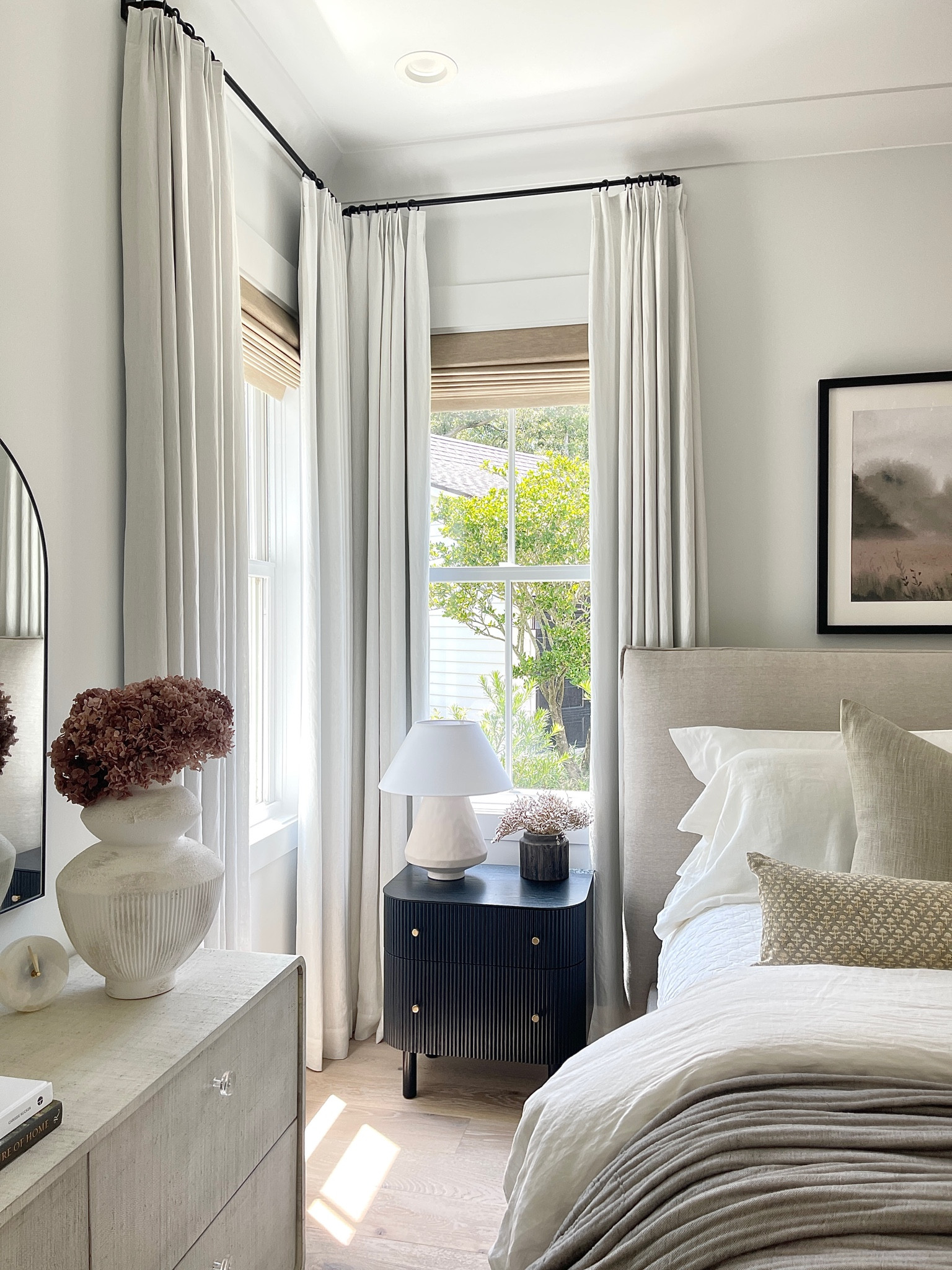 My Two Pages Curtains off-white Belgian linen curtains.  Curtain rods.  Bedroom decor. Black nightstand. Primary bedroom. White sheets. white linen duvet.  Primary bedroom. Black fluted nightstands.  White lamp. White vase. Dried florals. Fall florals.  Collection prints art.  Dresser.  Linen king bed.  Window shades    

#LTKover40 #LTKSeasonal #LTKhome