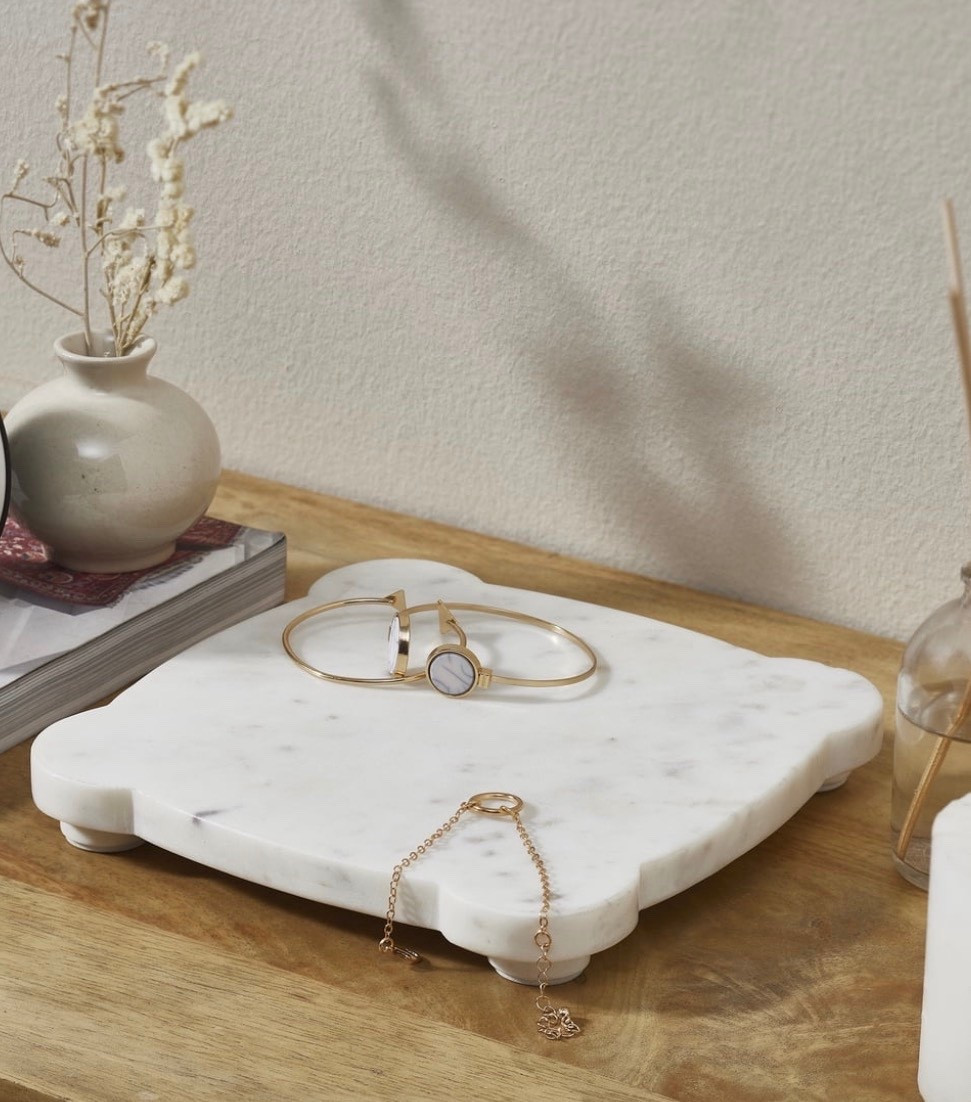 Bring understated elegance to your everyday surfaces with the My Texas House White/Grey 8" x 8" Marble Decorative Tray. Crafted with a smooth marble finish in soft white and grey tones, this decorative tray features gently rounded corners and a subtly elevated profile for a clean, refined look. Perfect for styling at your sink, vanity, coffee bar, or desk, it provides a chic spot for candles, jewelry, soap dispensers, or other small essentials. Created by home décor blogger and influencer Erin Vogelpohl, My Texas House brings Erin's signature modern farmhouse and fresh country style to every home

#LTKBeauty #LTKMothersDay #LTKmorningroutine