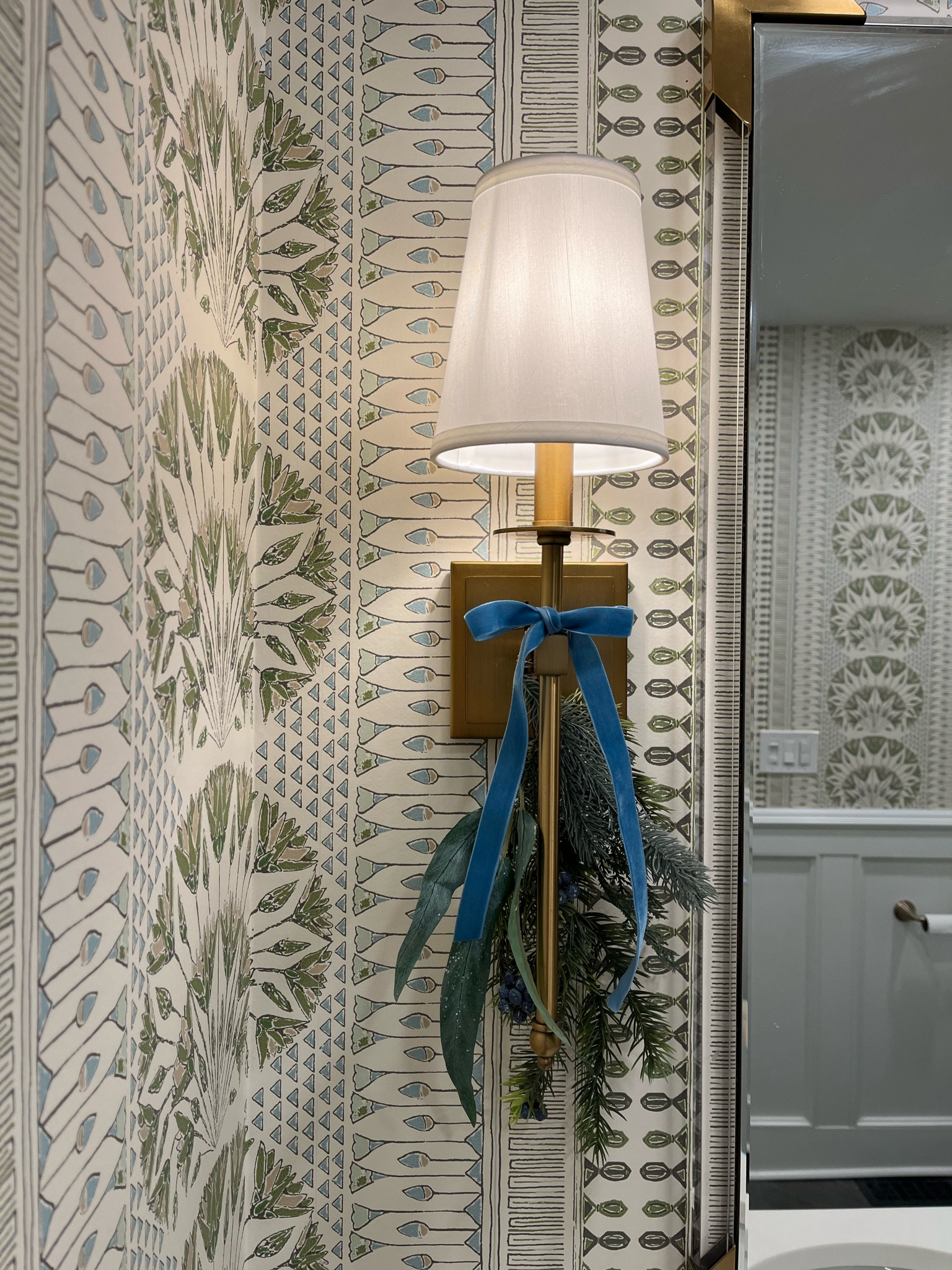 Grandmillennial Christmas decor blue velvet ribbon brass shade sconce lucite mirror Cairo Thibaut wallpaper blue and green wallpaper 