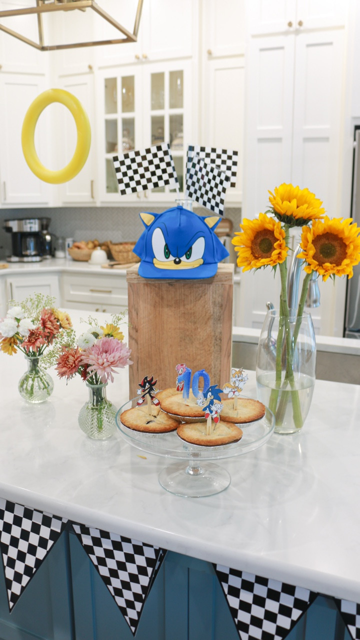 Sharing all the birthday party decor details, including the Sonic the hedgehog photo backdrop I setup for my niece’s 10th birthday. 

I spray painted 3 foam rings yellow to look like Sonic coins & hung them above my kitchen island using fishing line, so they looked like they were floating.

Afterwards, I uploaded the party themed graphic I designed to my Frame TV and set the tables. Sharing links!
.
.
.
.
.
.
.
.
.
Sonic birthday party | Sonic the Hedgehog birthday party | 10th birthday | kids birthday | DIY kids birthday party