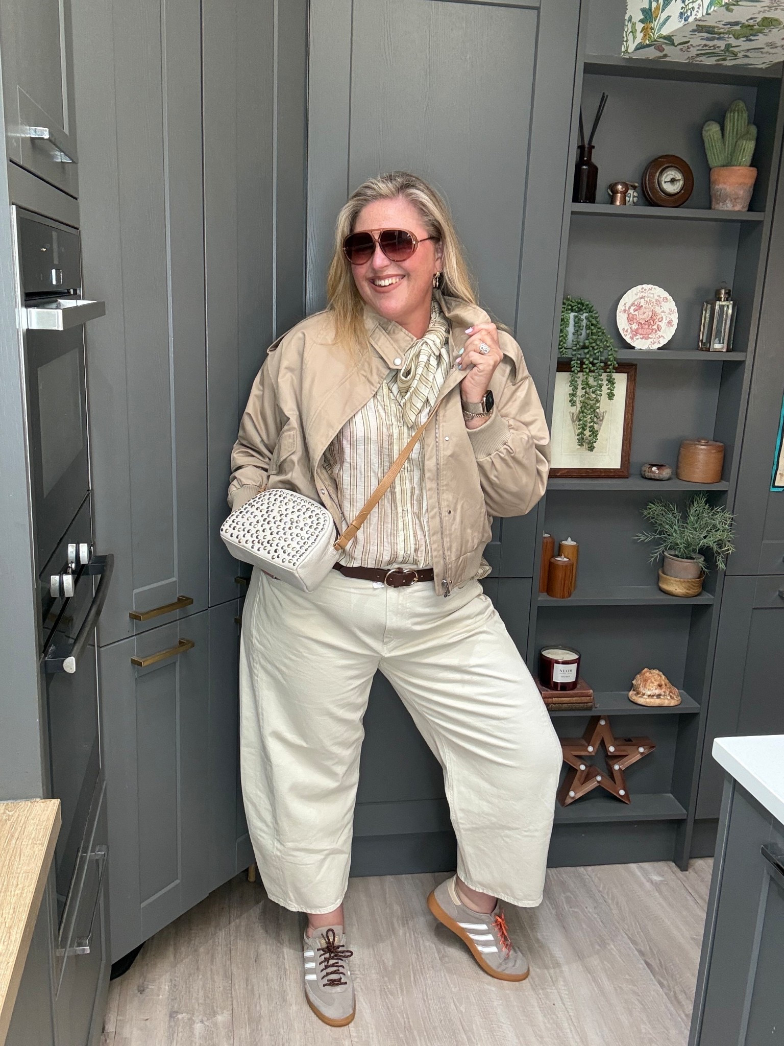 Ecru barrel jeans, brown striped bow shirt, beige bomber jacket, cream studded bag, beige trainers, sunglasses 

#LTKspring #LTKjeans #LTKplussize