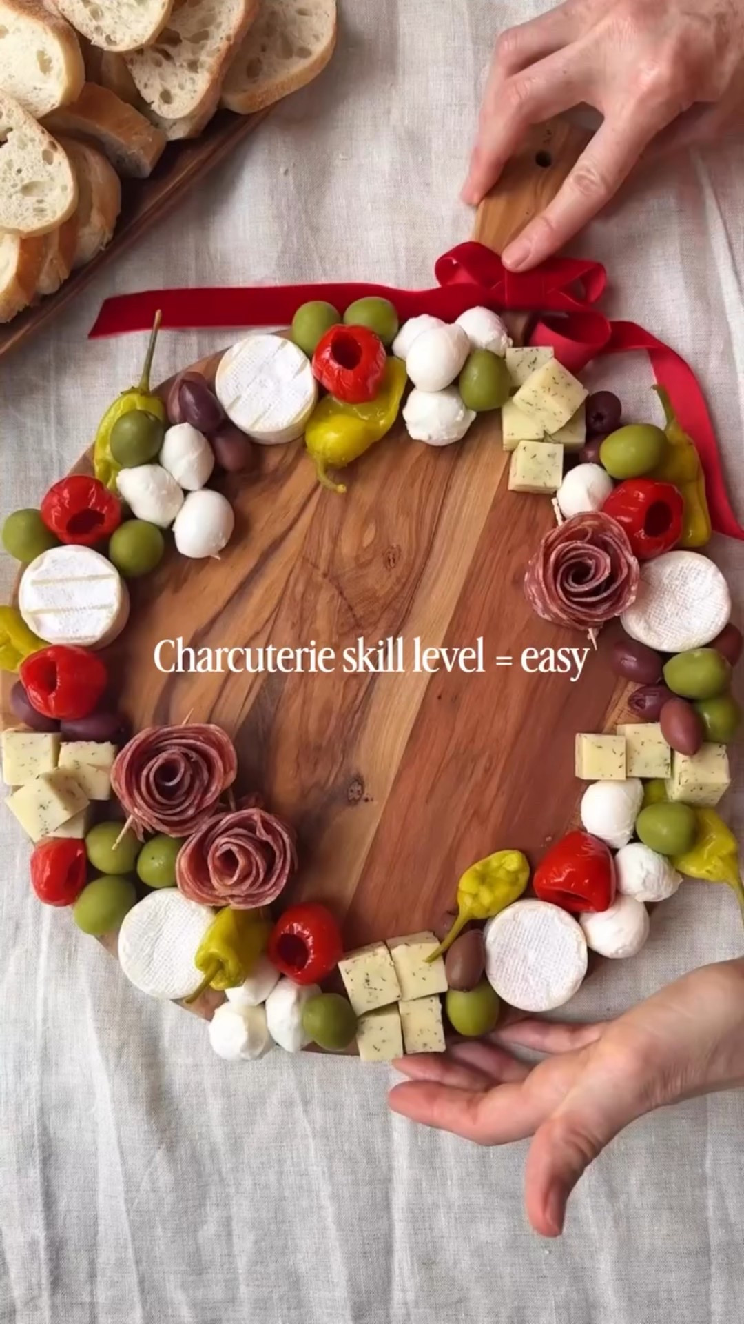 Ingredients
* 5 Brie bites  
* 4 oz mozzarella balls (Ciliegine)
* 4-5 oz dill Havarti cubed
* 3 salami rosettes (check out my tutorial)
* 2 oz Kalamata olives pitted
* 3-4 oz Castelvetrano olives
* 2 oz pepperoncini
* 2 oz peppadew peppers
* Fresh rosemary sprigs for garnish
* Crackers or crostini for serving
Instructions 
* Using the edge of a round board as a guide, space the brie bites, mozzarella balls, and cubed cheese out in a circle. 
* Evenly distribute olives, pepperoncini, and peppadews between (and on top of) the cheeses. Place the salami rosettes (I like to do two on the bottom and one on top) and garnish with rosemary sprigs to help define the wreath shape. 
* Serve with crackers or crostini and enjoy!

#LTKGiftGuide #LTKHoliday