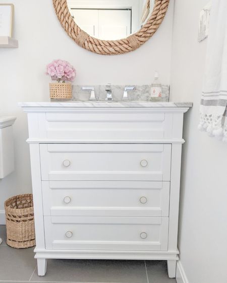 Went with a classic white vanity and a polished chrome faucet for our guest bath, but swapped out the knobs on the vanity to bring in a touch of gold for warmth! Floor tile was sourced locally.
-
home decor, coastal decor, beach house decor, beach decor, beach style, coastal home, coastal home decor, coastal decorating, coastal house decor, home accessories decor, coastal accessories, beach style, neutral bathroom, white bathroom, bathroom decor, coastal bathroom, bath accessories, polished chrome bathroom faucet, american standard faucet, square faucet, 2-handle faucet, white bathroom vanity, gold vanity knobs, 30” bathroom vanity, wayfair bathroom vanity, beach house bathroom, bathroom mirror, round mirror, woven mirror, rope mirror, serena & lily mirror, cane vases, wicker trash basket, woven trash basket, bathroom trash basket, bathroom hand towels, bathroom shelves, wood shelves, etsy shelves

#LTKhome #LTKstyletip #LTKunder100
