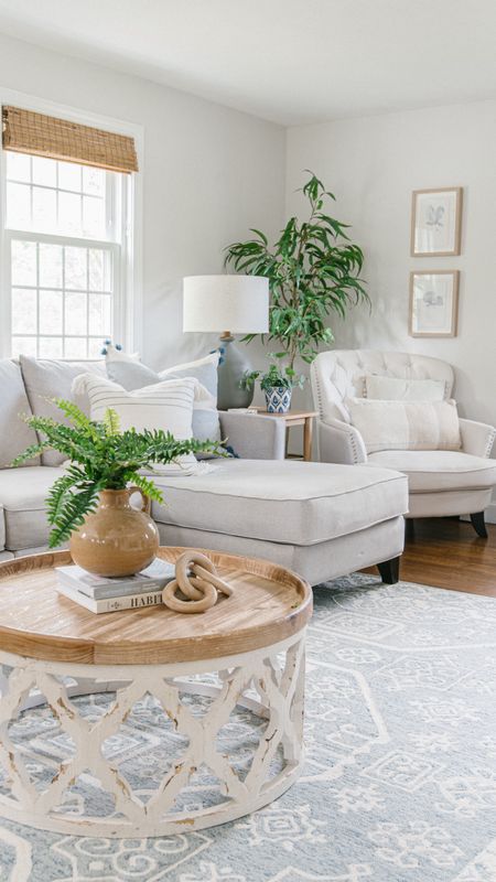 Coastal style living room with Ottoman couch, round coffee table, artificial flowers, and stems, home decor

#LTKhome #LTKfamily