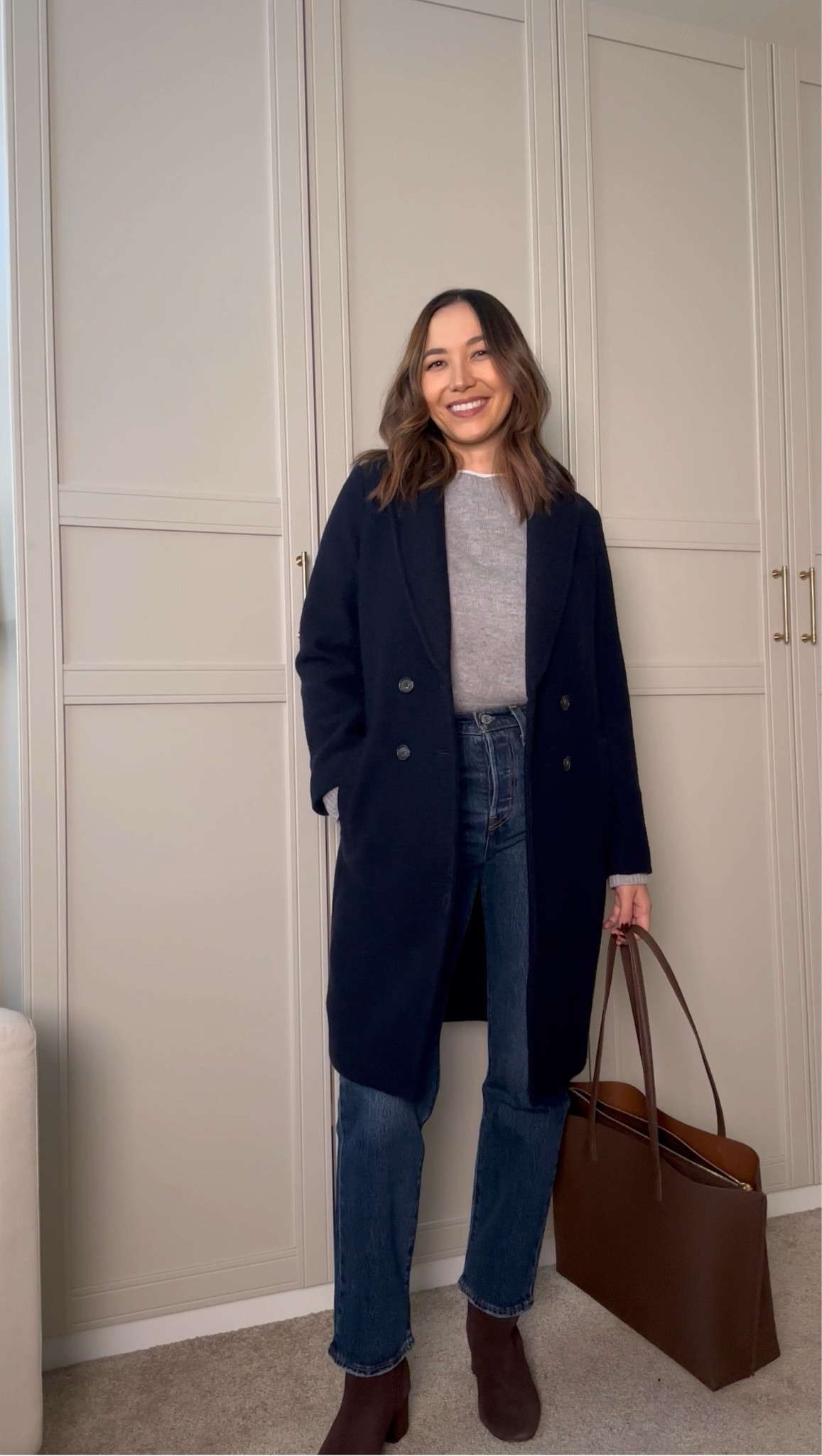 Minimal f/w outfit styling a navy coat 

Levi’s wedgie - indifferent indigo, 28” inseam 
Navy coat / gray sweater / blue jeans / waterproof brown boots / leather tote bag 

#LTKStyleTip #LTKSeasonal