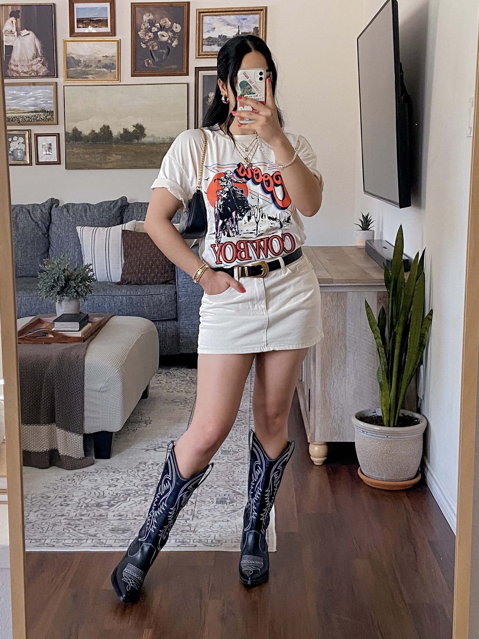 part 2: how i style an oversized graphic t-shirt 🖤 i’m wearing this t-shirt in a size medium and it has an oversized fit. the fabric is soft, comfy, and has some stretch. it’s available in 3 colors, i got the color apricot. here i styled the top with a monochromatic denim mini skirt, black cowboy boots, layers of necklaces & bracelets, a black shoulder bag, and a black belt with a gold buckle to tie in with the gold jewelry. 

#LTKStyleTip #LTKFindsUnder50 #LTKSeasonal