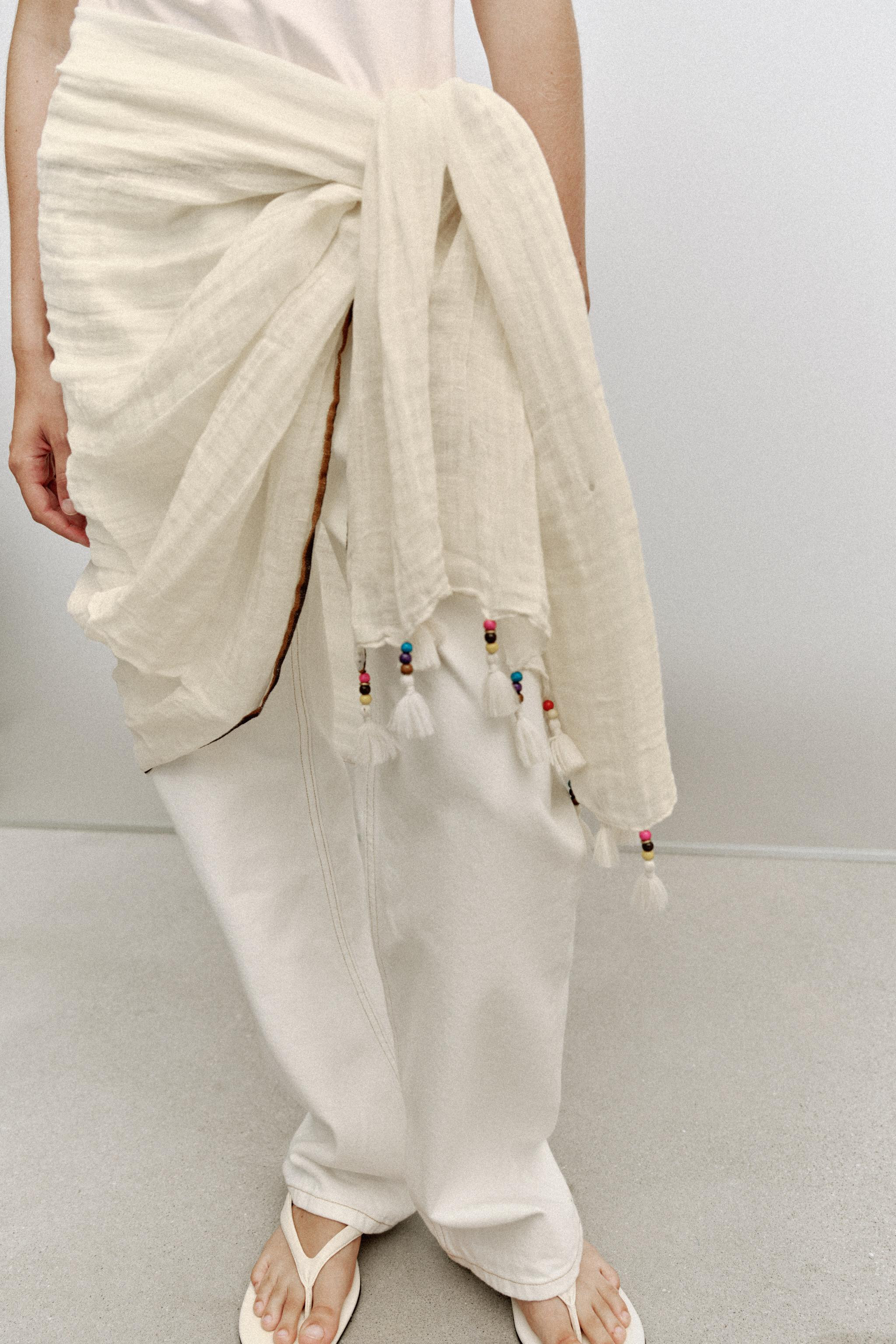 Solid-colored scarf made of a linen blend. Features a contrasting stripe detail. Finished with co... | Zara US
