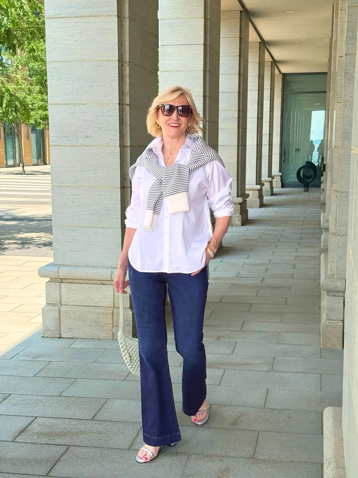 This is one of those outfits that just feels effortlessly pulled together. 🤍

I’m loving this classic white collared shirt from Spanx paired with jeans and a striped sweatshirt casually tied around my shoulders. Add the silver sandals for a little bit of shine, and you’ve got an easy, polished look without feeling overdressed. ✨

#LTKOver40 #LTKSeasonal #LTKootd