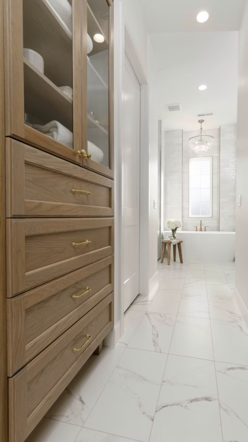 Who doesn’t love a built in bathroom hutch! 🤌🏻 Mixing warm wood cabinetry with soft marble tile keeps this master bath feeling bright but still grounded.

#LTKHome