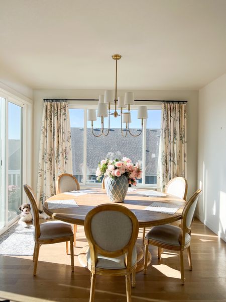 Round pedestal dining room table, light wood, French country dining room upholstered chairs, Vendome Visual Comfort brass chandelier, floral curtains.

#LTKxPrime #LTKhome #LTKsalealert