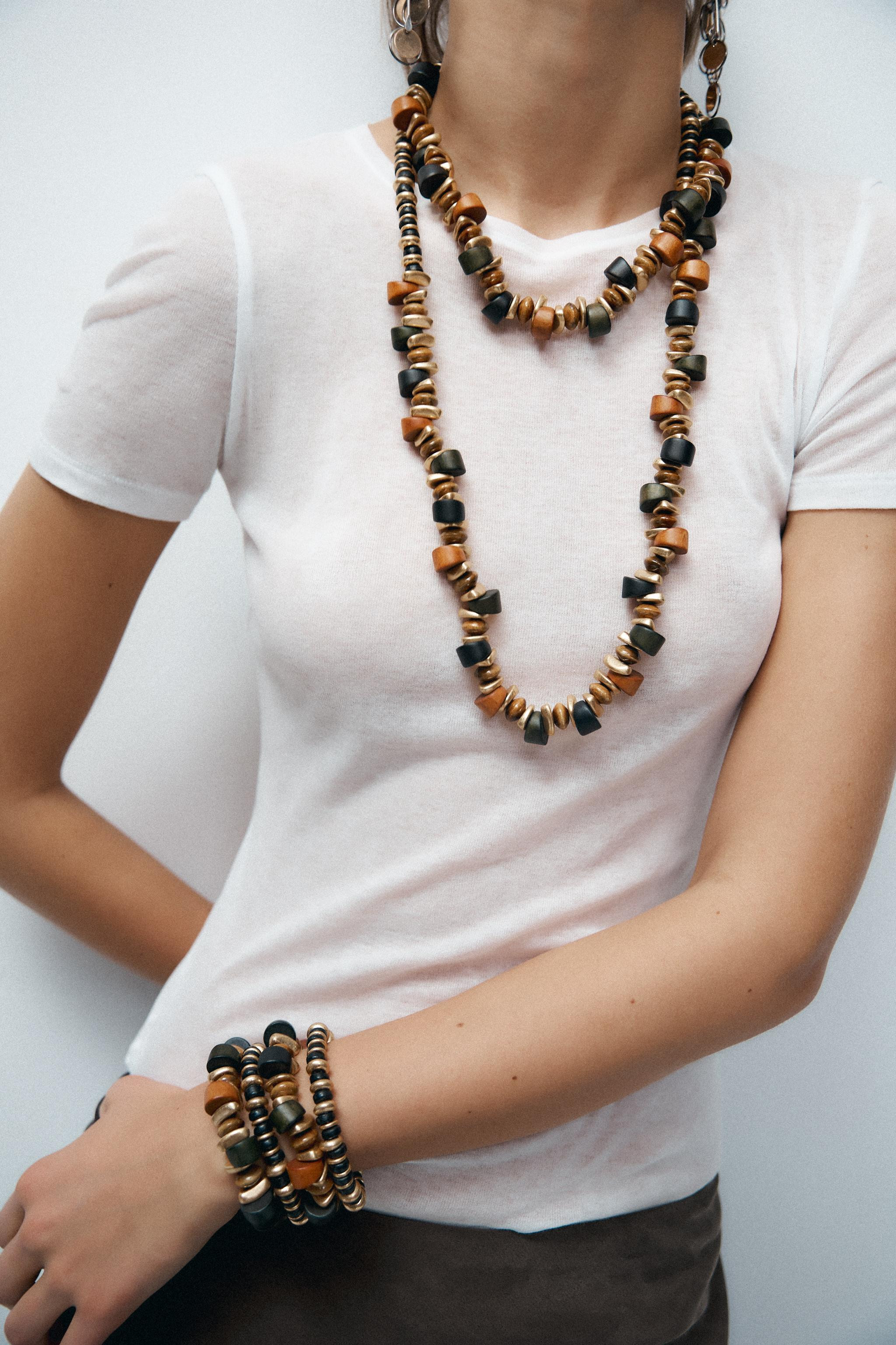 Pack of four stretch bracelets with irregular pieces made of wood and colored ceramic. | Zara US