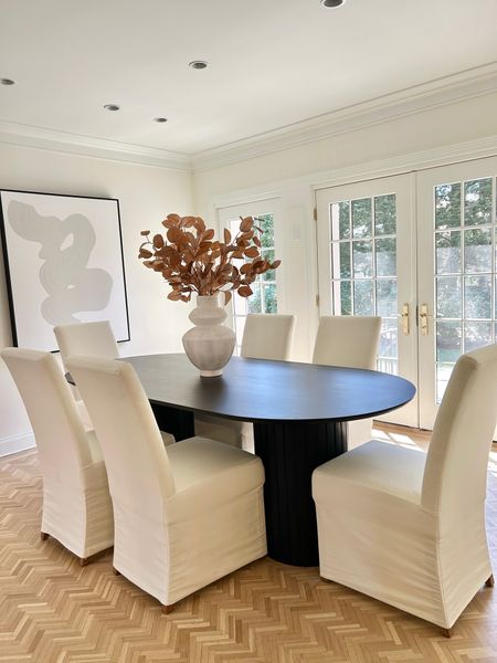 Sophisticated dining room. Black oval pedestal table with white slipcovered chairs. 

#diningtable #artwork #slipcoveredchairs

#LTKhome