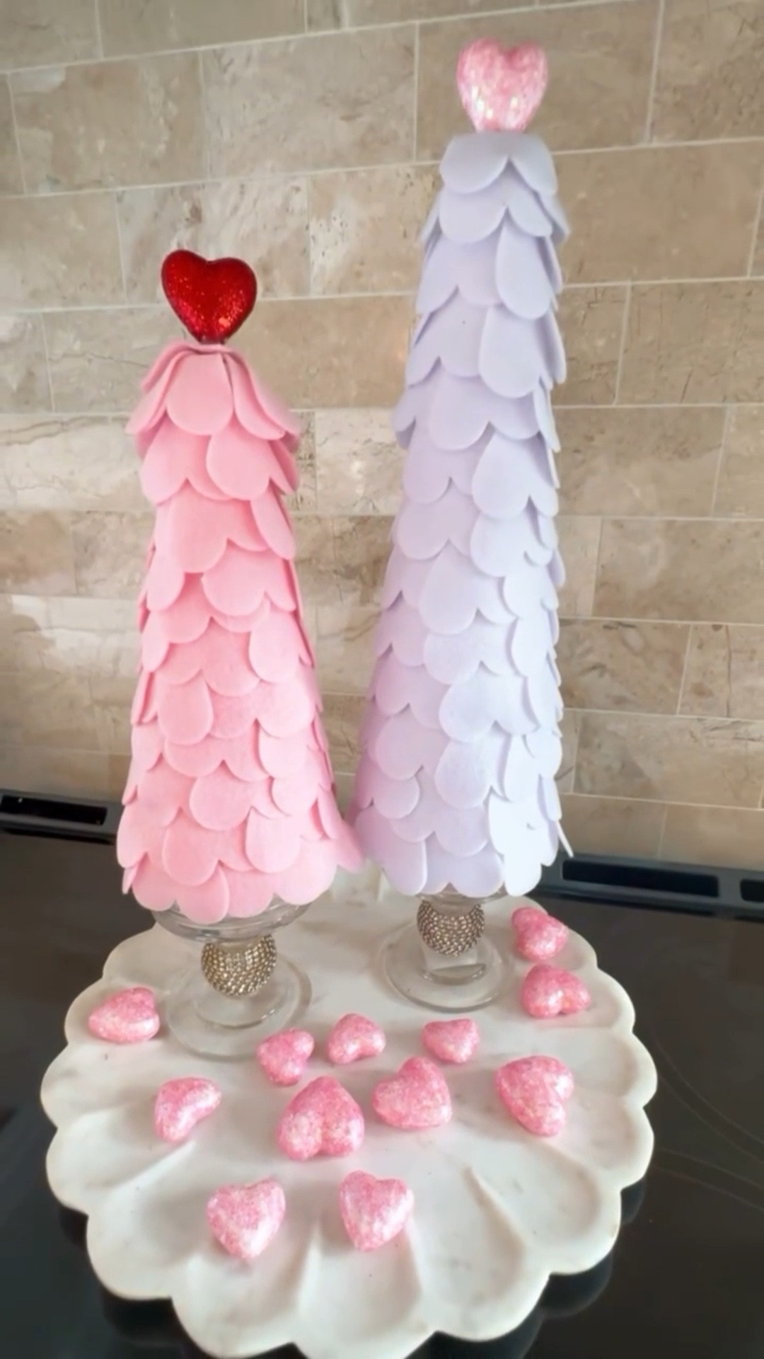 Sweet, simple Valentine charm 🤍💕 These pink and soft white felt cone trees with heart toppers add the perfect touch of love to a kitchen counter, coffee bar, or Valentine vignette. I styled them on a scalloped tray with glitter hearts for an easy, elevated seasonal look that transitions beautifully from winter to Valentine’s Day. Lightweight, reusable, and timeless—this is the kind of décor you’ll reach for year after year.

#LTKHome #LTKFindsUnder50 #LTKSeasonal