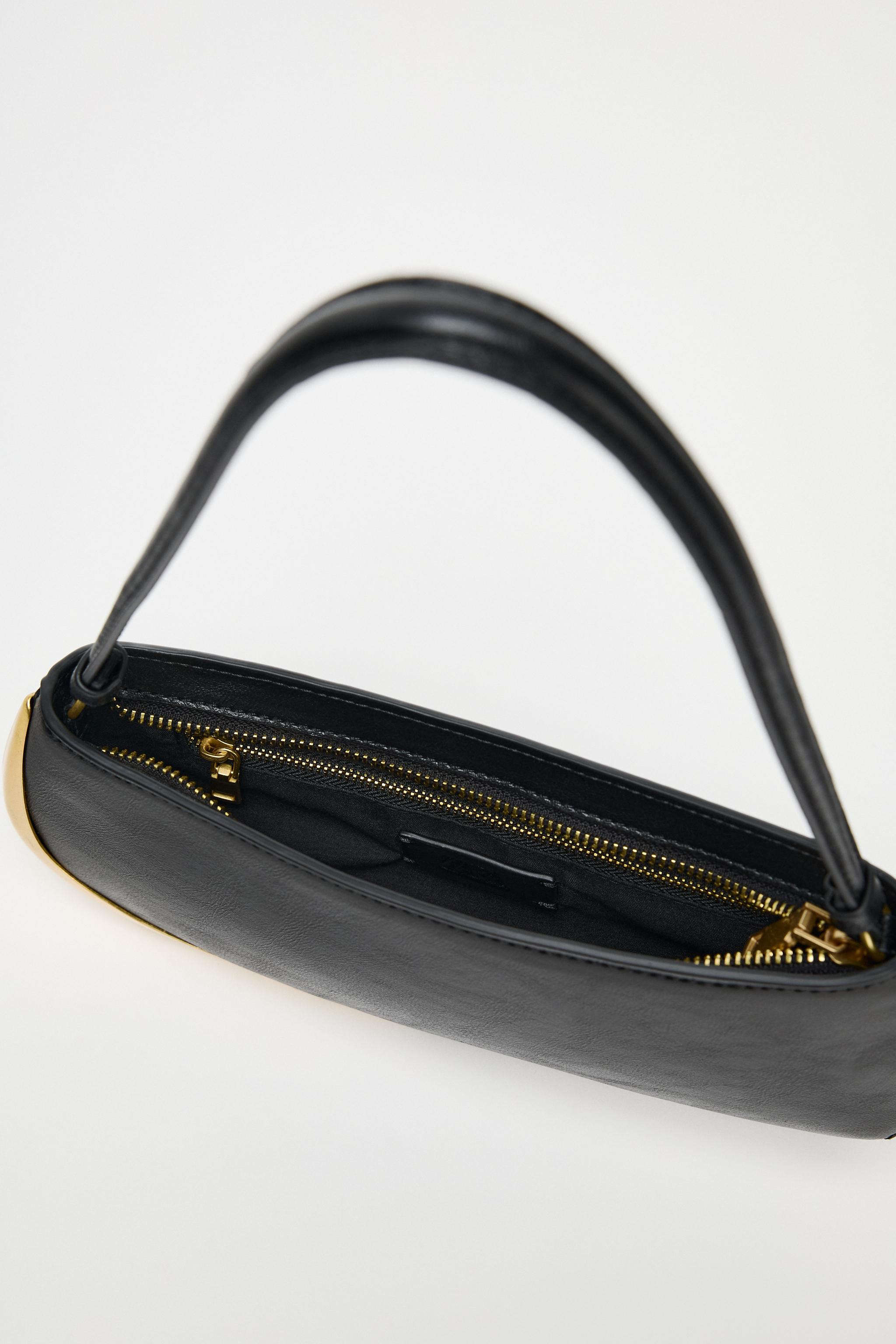 Elongated shoulder bag. Gold metallic detail on one side. Interior zip pocket. Shoulder strap. Zi... | Zara US