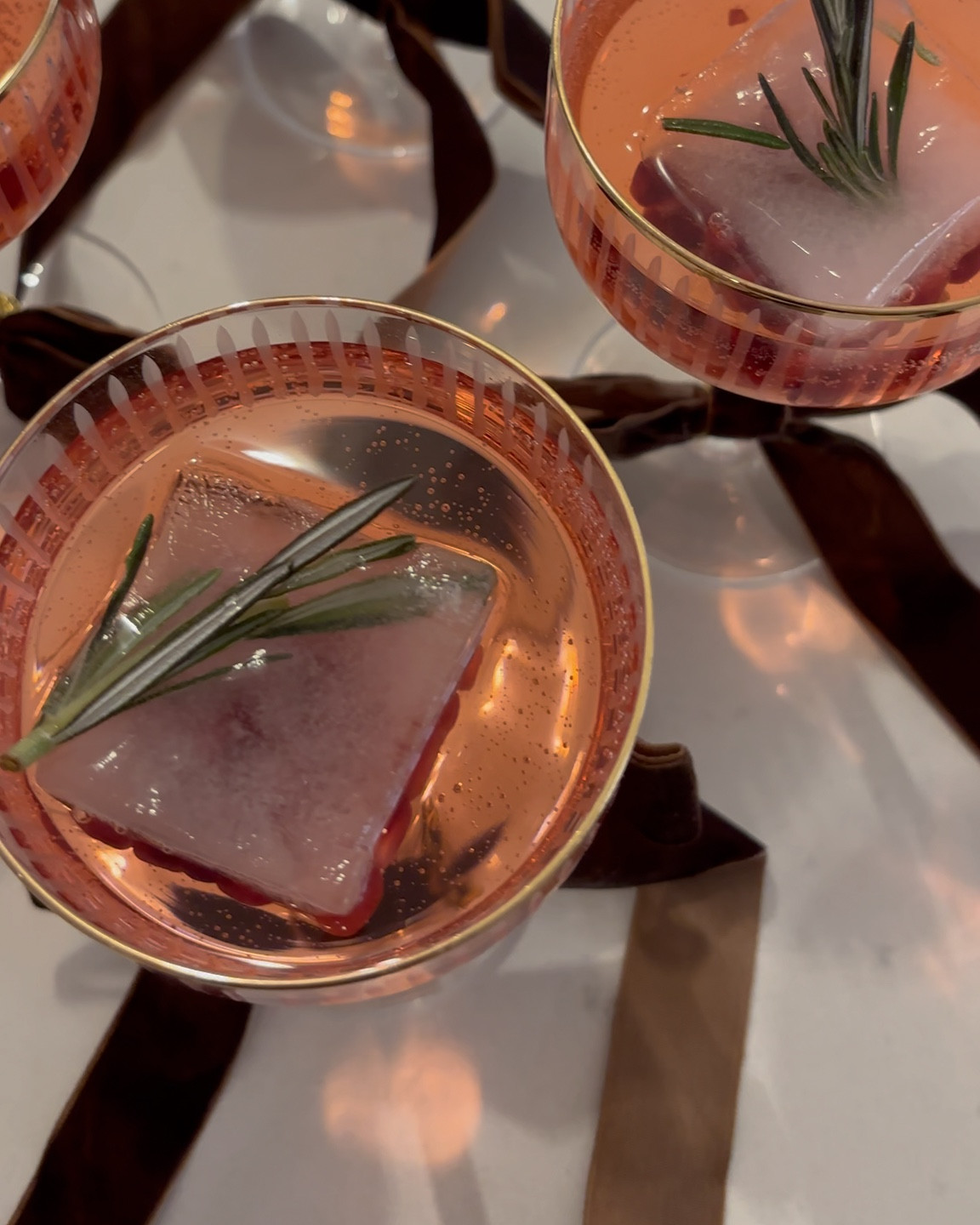 Hosting a holiday party? Serve these festive mocktails ✨ linked below are the ice cube trays I used, similar champagne coupes, and velvet bows! Head to my IG for the drink recipe 🥂