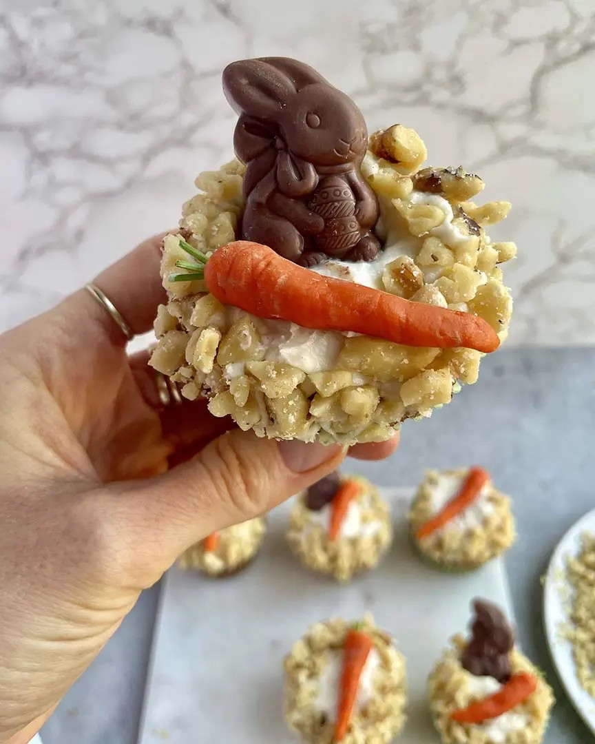 Instructions 
* In a small bowl, combine the marzipan and food coloring until evenly incorporated. Add more food coloring, as needed, to reach the desired color. Make sure to add the coloring in small amounts, it’s easy to over do it! (pro tip: wear gloves when mixing in the color and molding the carrots unless you want orange hands.) 
* On a flat, clean surface, roll the marzipan out into a long, slim log and divide into even 2-inch segments. Shape each segment into carrot-like cone shapes.  
* Dip a toothpick in the cocoa powder, then use the coated toothpick to create grooves and lines to give the marzipan carrots a realistic, fresh-from-the-garden look. 
* To top it off, cut a parsley stem to resemble a carrot greens. I prefer parsley because it doesn’t have a super strong flavor, but you can use any stemmy green herb you have on hand! 
* Nestle the carrot on top of the icing alongside the chocolate bunny. Sprinkle the icing with walnuts or press them into the outside edge of the icing to create a delicious, nutty ring.y

#LTKHome #LTKfoodie #LTKSeasonal