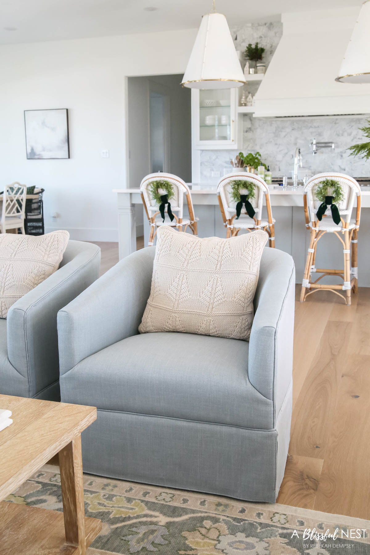 A timeless holiday look made simple. Tap to get the decor pieces that make it shine.
 sky blue swivel accent chair, textured throw pillow, wooden spoons, bamboo dish scrub brushes, Mrs. Meyer's kitchen set, European mill, suede velvet ribbon, faux juniper wreath, Mud Pie utensil holder, ceramic Christmas village houses, faux blueberry stems 

 #LTKHoliday #LTKSeasonal #LTKHome