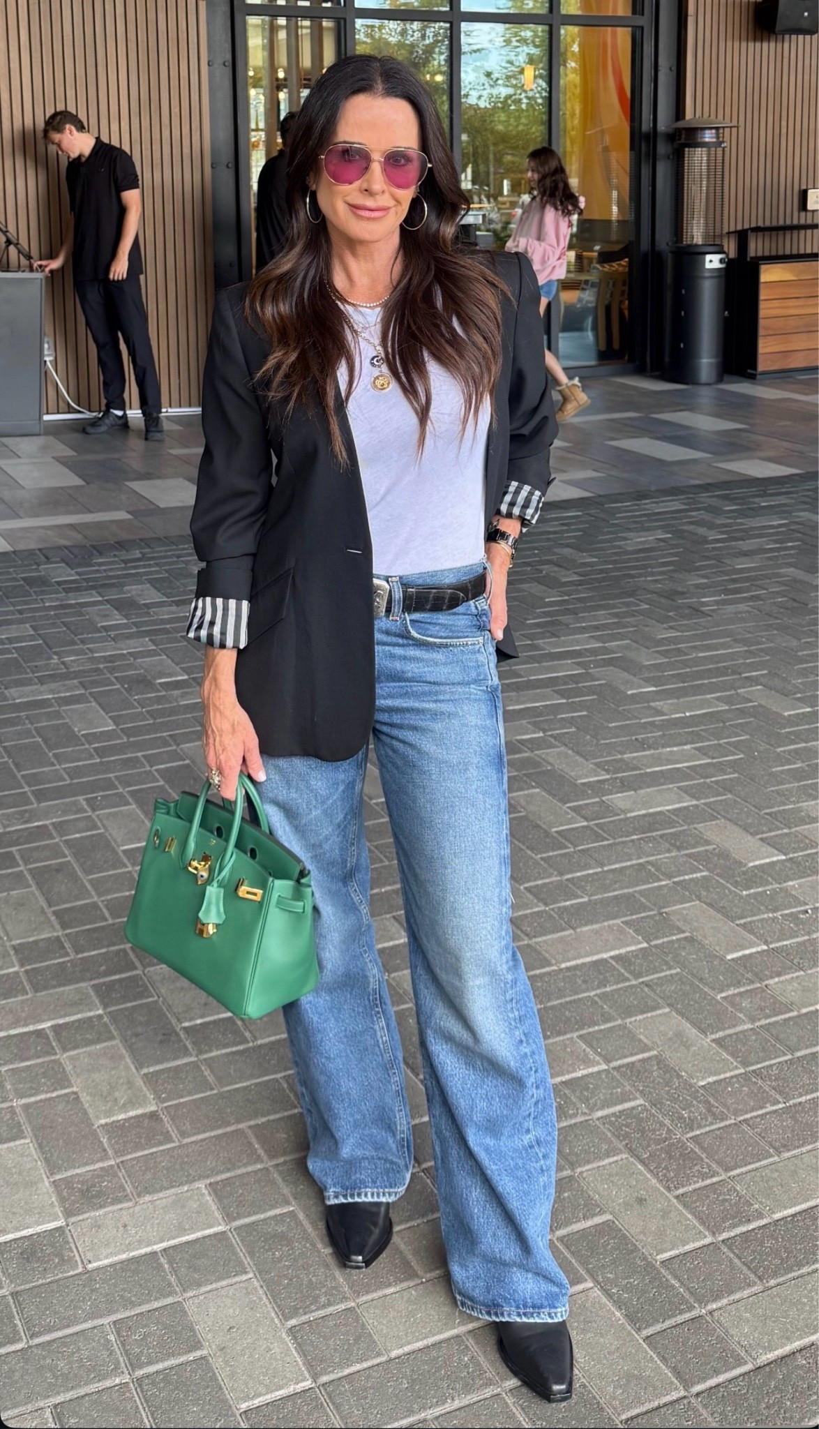 Kyle Richards wearing straight leg jeans perfectly fitting T-shirts, square toe boots gold aviator sunglasses