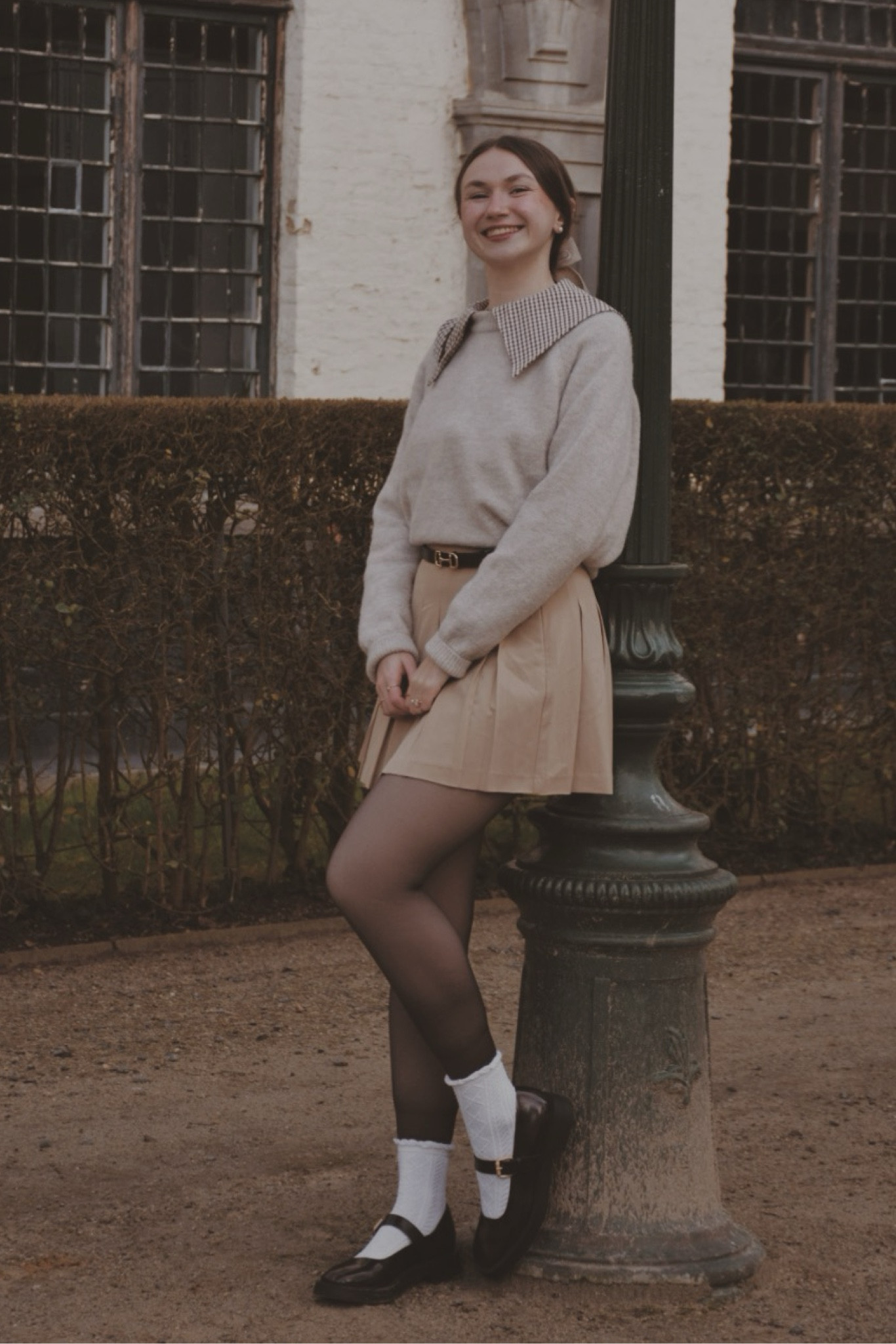 Brown gingham shirt
Beige wool sweater
Beige pleated skirt 
Brown Mary Jane's