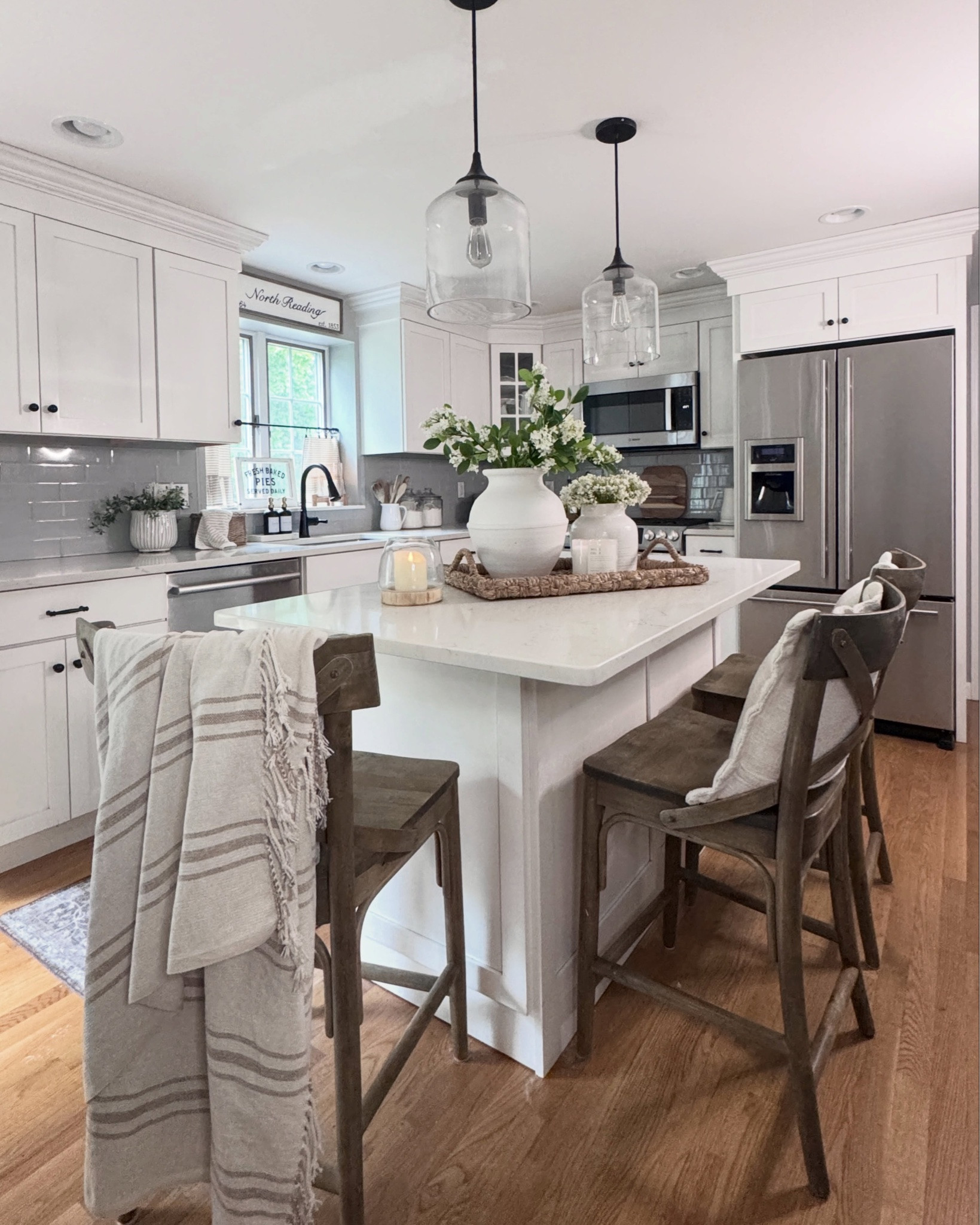 Sharing a few stills of my kitchen today. I switched over to my seagrass tray because it’s officially June and I always think seagrass looks so summery & beachy. And would you believe that beautiful glazed & fluted vase on my sink counter is from Home Depot? I actually got it over the winter to use as a pot for my countertop trees - as you’ll see in my last photo (& it comes in 3 sizes!) Now I’m using it for my summer greenery. I love using pieces year-round in different ways throughout my home. You don’t need to buy new things each season! It’s all in how you style it. 

Comment “SHOP” for links to my tray, the glazed pots and all my other kitchen decor on my LTK. 

Summer decor, kitchen love, white kitchen, kitchen design, home decor, kitchen refresh, white kitchen cabinets 

#summerdecor #whitekitchen #kitchenlove #homedecor #kitchendesign