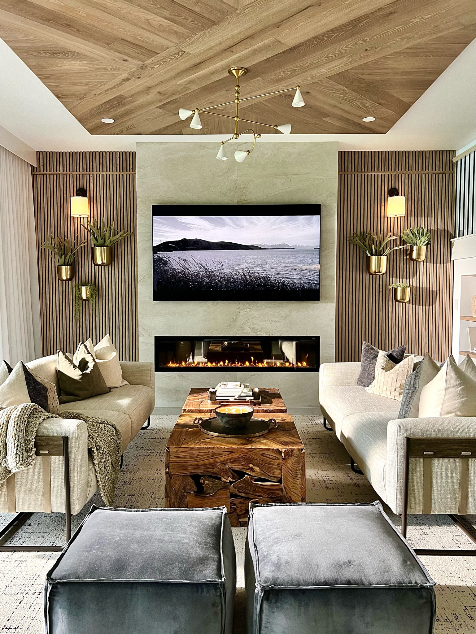 This living room is modern and cozy thanks to the warm wood wall paneling, adding texture on the ceiling, a fireplace and how the sconces and chandelier create soft lighting ambiance. If you’re living room isn’t cozy, here’s your sign to help get it there! 

#LTKhome #LTKparties #LTKSale