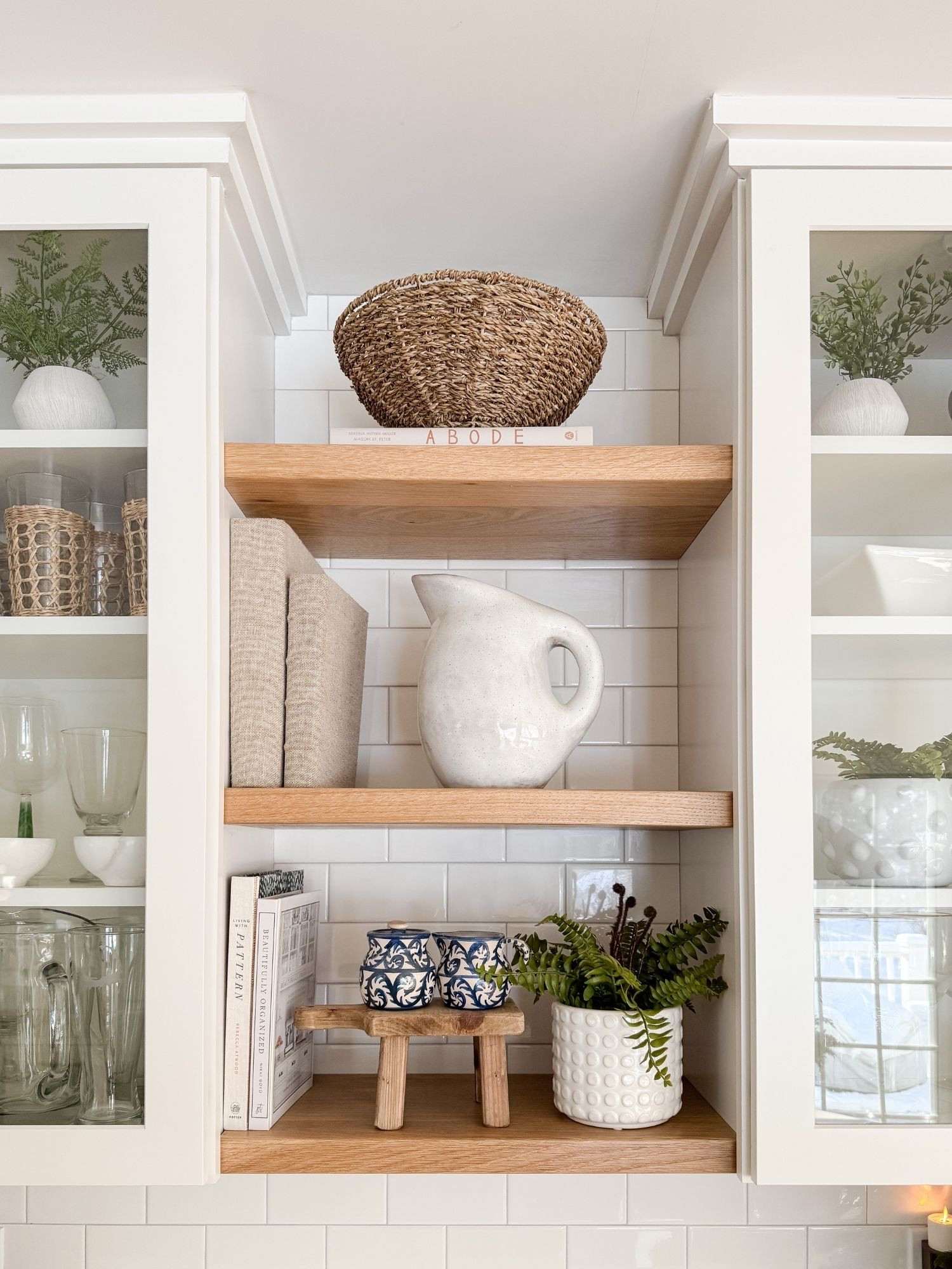 Close up coastal kitchen shelf styling featuring ceramic pitchers, woven baskets, and natural greenery that bring warmth to a classic cape cod kitchen. These simple layers make the space feel curated yet effortless. Cape cod kitchen decor, coastal kitchen shelves, neutral kitchen styling, ceramic pitcher decor, woven basket styling, amazon finds kitchen accents, sherri calnan home

#LTKHome