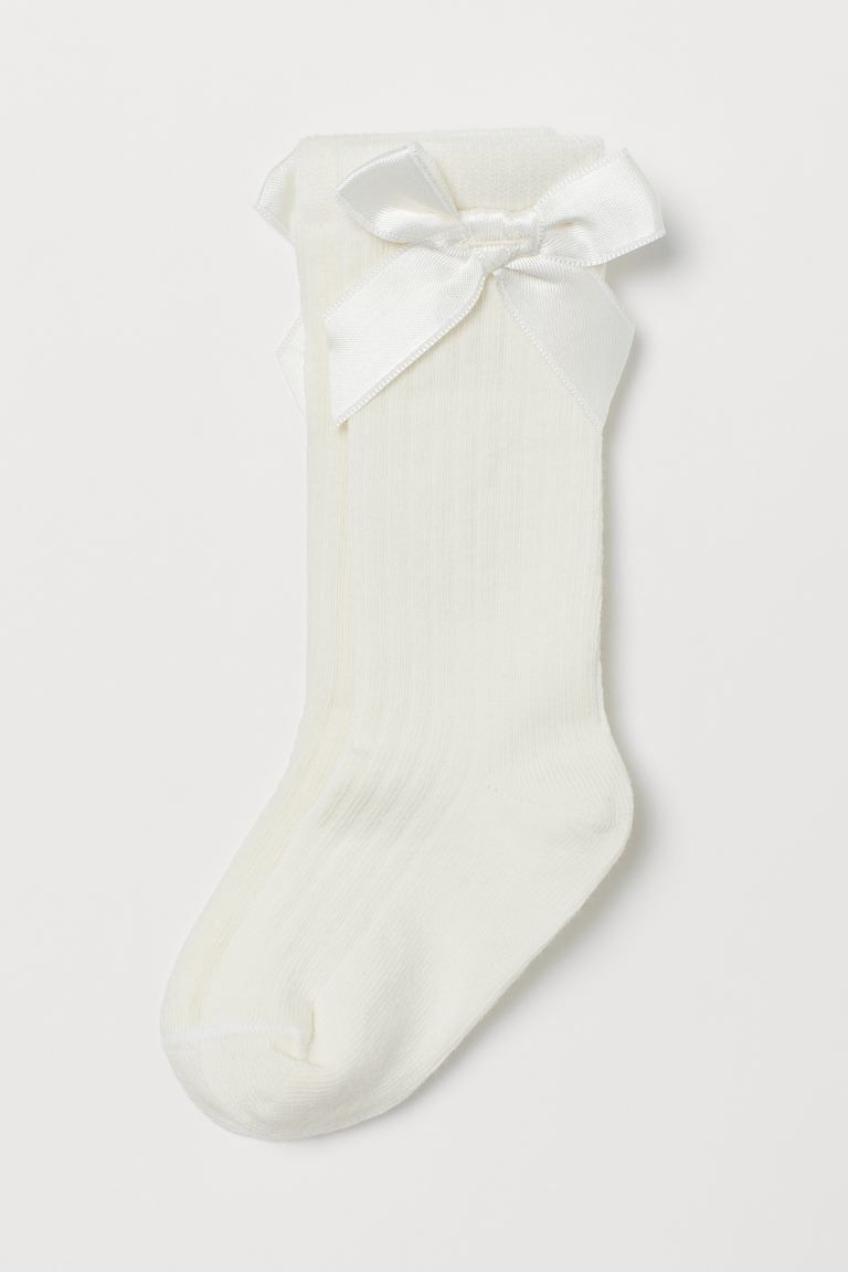 Rib-knit knee socks in a soft cotton blend with a decorative satin bow at top. | H&M (US + CA)