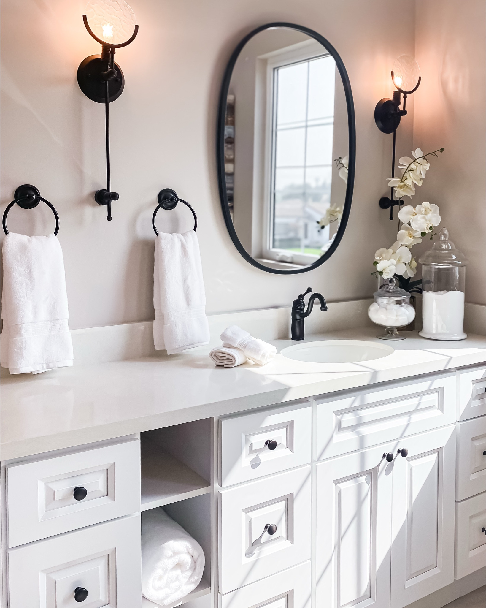 Clean lines and soothing neutrals define this bright bathroom space. Loving the contrast of the black fixtures against the crisp white cabinetry!

#LTKHome
