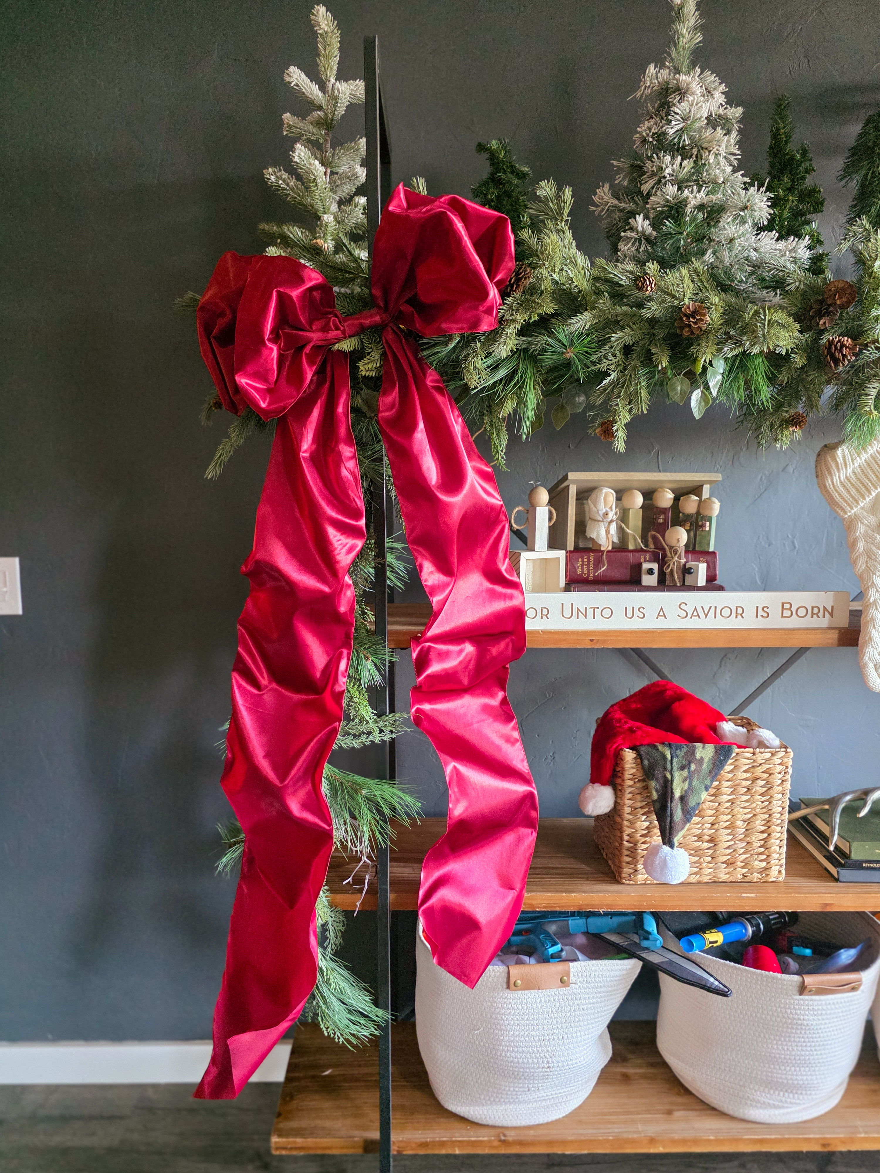 Holiday shelves with a standout bow: 
Deep red satin, perfectly floppy, and tied right into the garland. Instant mood. 

 #LTKHoliday #LTKHome #LTKFindsUnder50
