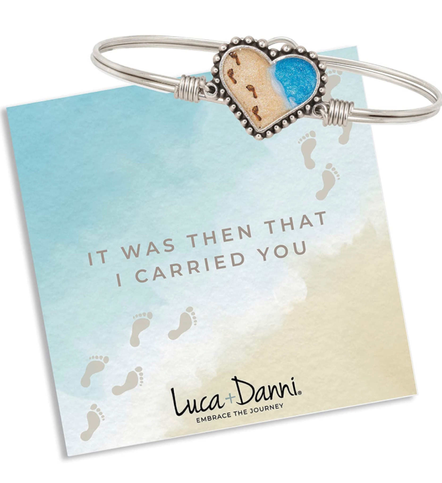 Luca + Danni Footprints In The Sand Bangle Bracelet. You never walk alone. Renew your faith and fortitude daily in this Footprints in the Sand Bracelet, based on a timeless devotional fable. A delicate printed beach scene depicts a single row of footprints, framed in a handcrafted heart-shaped setting.

#lucaanddanni #beach #ocean #heart #madeinamerica

#LTKU #LTKtravel #LTKFind