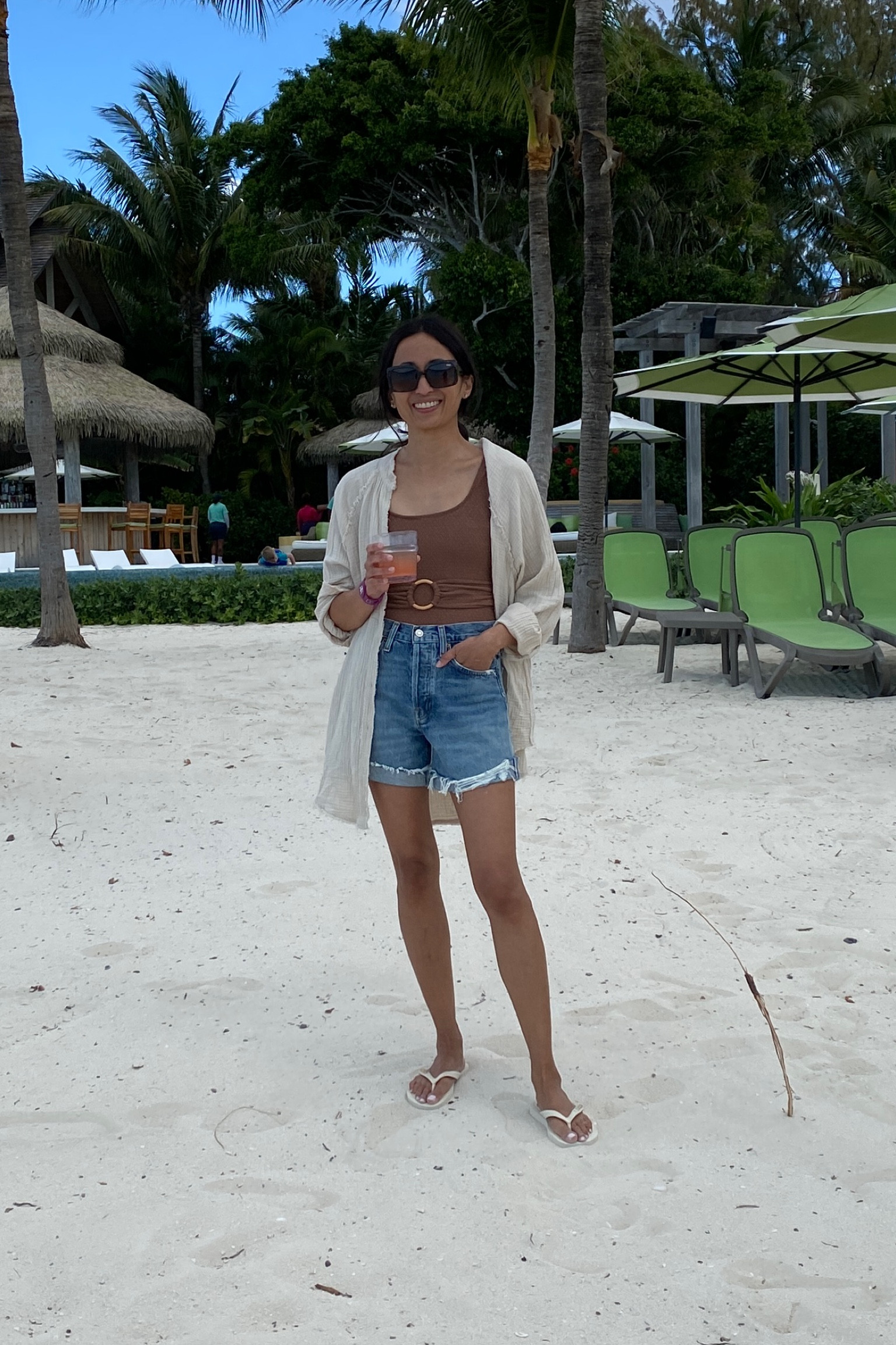Vacation outfit. Cruise outfit. Beach outfit. Pool outfit. One-piece swimsuit. Swimsuit coverup. Denim shorts. Flip-flop sandals. Flip-flops  
Sling bag