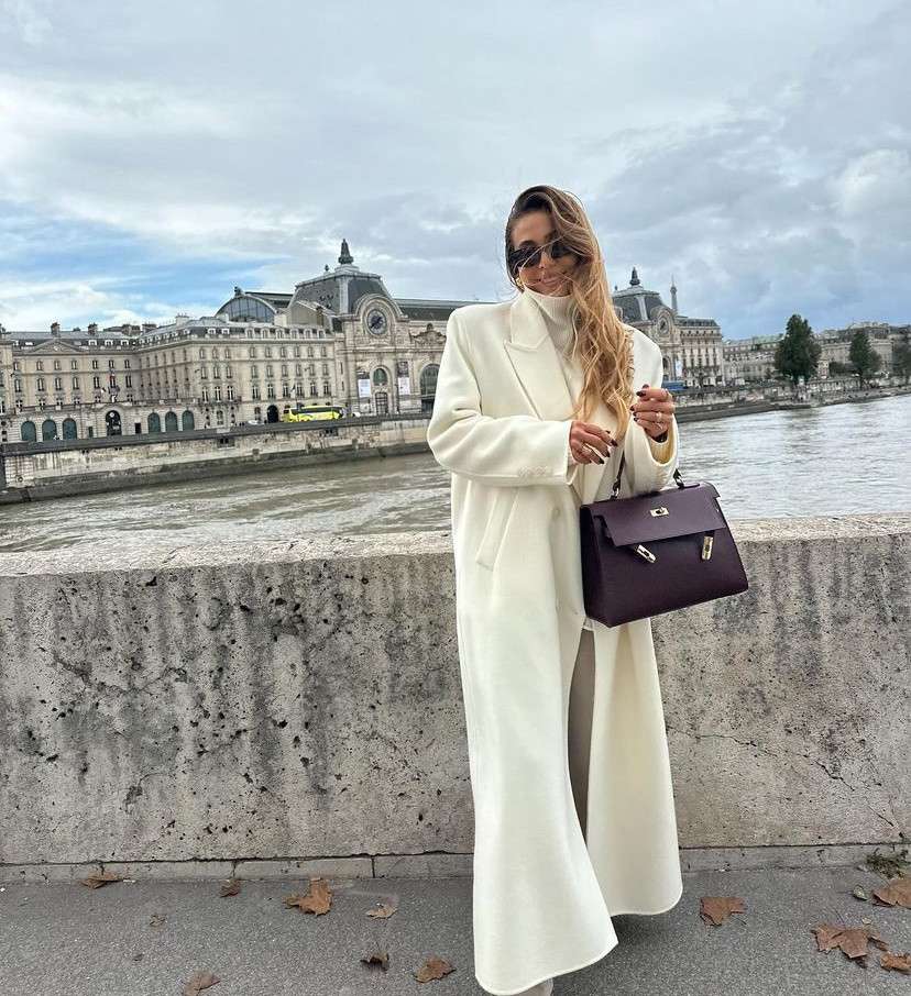 Winter outfit 
White long coat 
Dark purple  top handle bag 
White sweater 
Khaki pants 

#LTKTravel #LTKStyleTip #LTKWorkwear