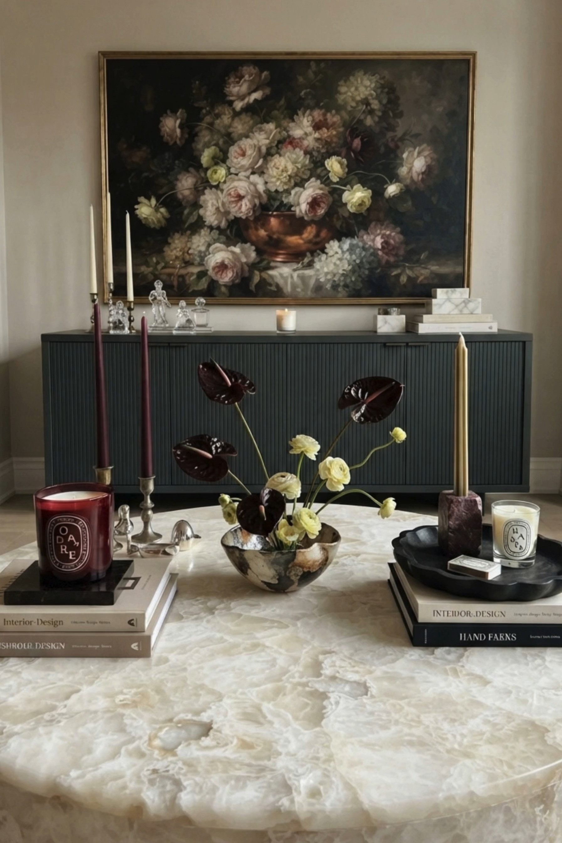 Elevated Moody Living Room Styling 🕯️ This sophisticated space blends modern luxury with romantic old-world details, featuring a statement floral still-life painting, dark fluted sideboard, dramatic burgundy taper candles, sculptural florals, stacked coffee table books, and a stunning round stone coffee table. Deep wine tones, creamy neutrals, crystal accents, and warm metallic finishes create a collected, high-end look that feels especially beautiful for fall and the cozy season. 🖤 If you want to see more content like this, FOLLOW maeveandmodern on LTK, Instagram, and Pinterest! Check out our blog where we post daily, maeveandmodern.com! Moody Living Room Decor | Luxury Living Room | Fall Home Decor | Coffee Table Styling | Stone Coffee Table | Round Coffee Table | Marble Coffee Table | Floral Still Life Art | Oversized Wall Art | Vintage Inspired Art | Dark Wood Sideboard | Fluted Cabinet | Burgundy Home Decor | Burgundy Candles | Taper Candle Holders | Designer Coffee Table Books | Sculptural Florals | Anthurium Arrangement | Romantic Interiors | Old World Decor | Modern Traditional Decor | Transitional Home Decor | Collected Interiors | Neutral Living Room | Elevated Home Decor | Cozy Fall Interiors | Designer Home Inspiration | Statement Artwork | Moody Fall Decor | Timeless Interior Design

#LTKHome #LTKSaleAlert #LTKSeasonal