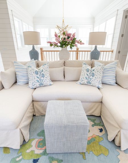 Our loft living room decorated for spring! I used these pink lilac stems, ribbed white vase, colorful oushak rug, linen sectional, light wood console table, blue lamps, striped ottoman cube, brushstroke throw pillow and floral pillow for pops of spring. See our full spring home tour here: https://lifeonvirginiastreet.com/2024-spring-home-tour/
.
#ltkhome #ltksalealert #ltkfindsunder50 #ltkfindsunder100 #ltkstyletip #ltkseasonal spring living room, sectional styling, colorful spring decor

#LTKhome #LTKSeasonal #LTKsalealert