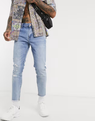 ASOS DESIGN cropped skinny jeans in light wash with raw hem and busted knee | ASOS (Global)