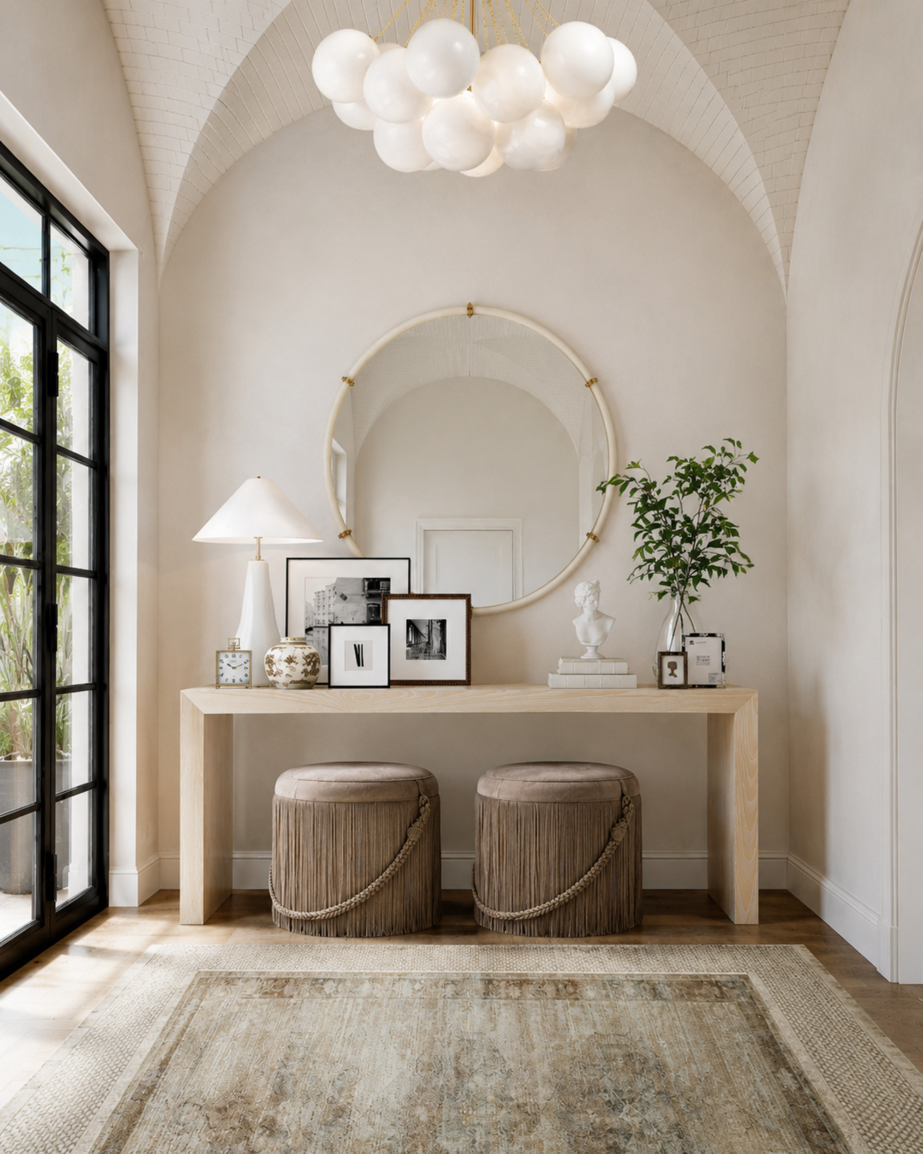 Classic entryway, but make it feel collected. I love the mix of the pale wood console, oversized round mirror, sculptural lighting, layered artwork, and fringe ottomans tucked underneath. It feels elegant without being too formal, and the soft neutral palette keeps everything calm and airy.

I may receive a commission when you shop through my links. Tap to shop the pieces I’d use to recreate this look. 

 #LTKHome