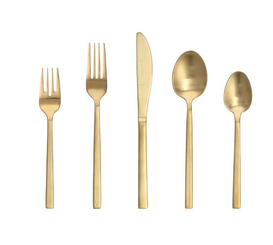 A five-piece place setting of brushed gold flatware