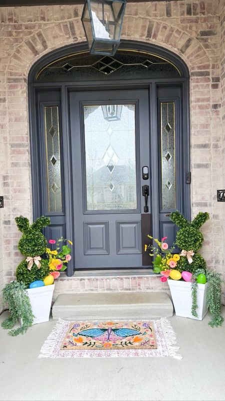 Front porch decor for Easter or Spring! Love the bright colors in the doormat and the bunny topiaries 

#LTKfamily #LTKhome #LTKSpringSale