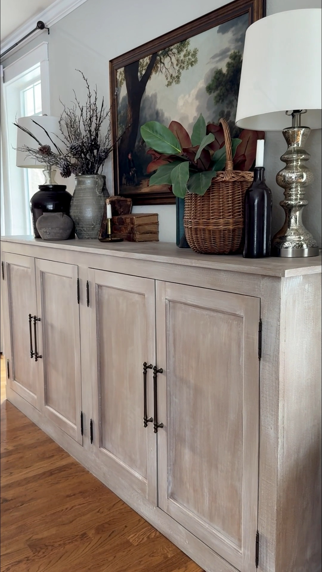  European antique charm ✨ Our sideboard makeover brings collected, curated style to life.
We layered vintage and Amazon pottery that feels timeless, icy and snowy winter stems, and old books to add story and depth. Vintage brass candleholders and antique-style duck head bookends (Amazon find!) give character, while a European basket with realistic magnolia stems adds softness and life.
The look is grounded with a beautiful equestrian art print from a small shop, and mercury lamps on each end provide perfect balance and symmetry. Every layer brings texture, history, and effortless European farmhouse elegance 🤍