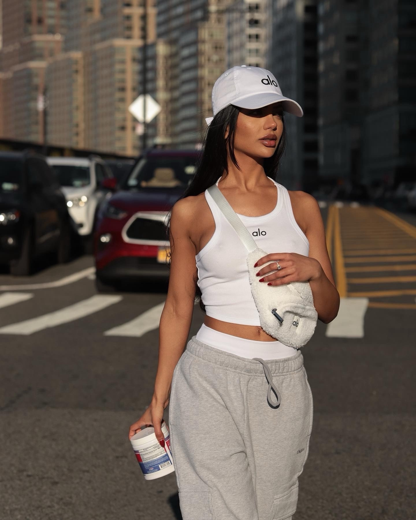 Wearing a size xs in this white Alo tank. Super casual and trendy is always the look. I paired it up with their signature hat  and under my sweats I’m wearing their white tights that feel so soft to the touch and are so comfy & stretchy. Wearing a size xs in their tights. The Sherpa fanny pack ties up the look perfectly. My sweats are from Aritzia and I happen to have them in every color too cause when I love how something feels and fits.. I need a variety of them. Wearing size xxs (short) in their sweats. I love that they have different lengths considering I’m 5ft tall and I usually have to tailor things. 

#LTKstyletip #LTKfitness #LTKGiftGuide