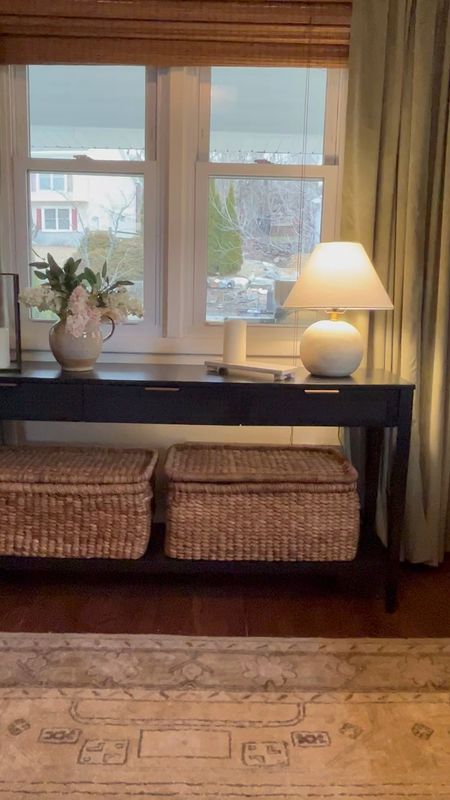 Woven baskets under a black console table with three drawers