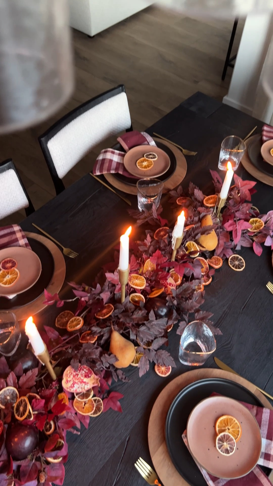 Fall centerpiece with dried fruit, dried orange centerpiece, burgundy fall tablescape, moody fall table decor, pomegranate centerpiece, fall garland centerpiece, autumn table setting, fall hosting ideas, Thanksgiving tablescape, burgundy plaid napkins, black dinnerware, wood chargers, gold flatware, brass taper candle holders, white taper candles and fall dining room decor.

#LTKHome #LTKSeasonal