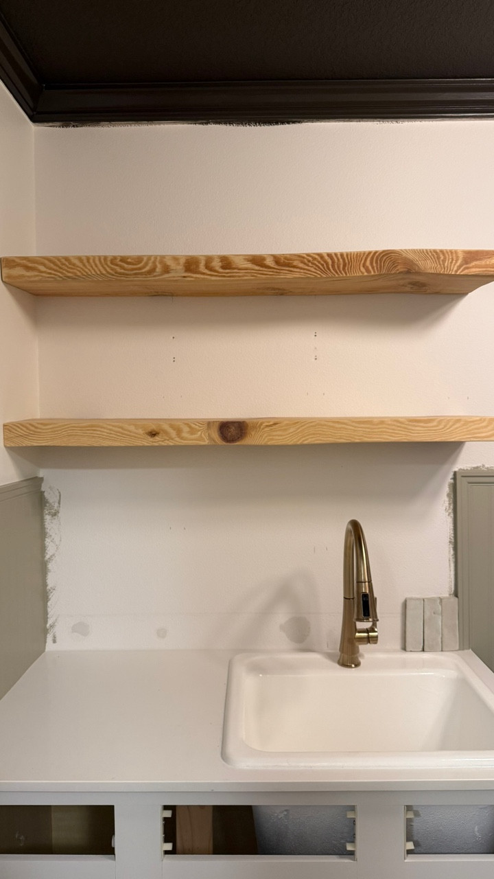 Floating shelves are very beginner DIY friendly. You cut your wood to size, sand, drill your holes for the pegs, mark on your wall where they will be going, the pegs get fastened to a stud, slide your shelf on. That’s it! You can stain beforehand as well but we didn’t because we weren’t sure what we wanted to do. 

Dimensions of our shelves: 
- 4’ long
- 10” wide 
- 2.5” thick 

We are staining the floating shelves, painting the cabinet, and installing the tile next! So close to the finish line. 

I linked our peg kit and shelf option! 

#diy #laundryroom #buildergradeupgrade #floatingshelves #interiors #makingahouseahome #homeimprovement #paint #interiordesign

#LTKHome