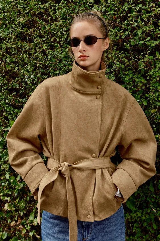 Stand-up collar jacket with long sleeves. Features front pockets. Matching fabric belt detail and... | Zara US