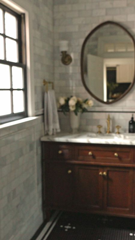 Shop Greta’s Bathroom 🖤 full sources can be found at ChrisLovesJulia.com/shop-our-house

Tiled bathroom, walnut vanity, wood arched mirror, brass faucet, sconce

#LTKhome #LTKVideo