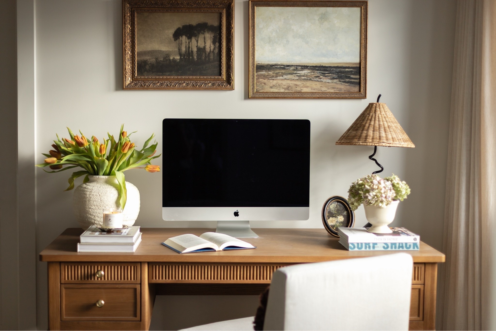 A few of my favorite details from our home office: a woven lamp, warm wood desk, vintage-inspired frame, coffee table books and simple florals. I love mixing natural textures with darker accents and antique-inspired pieces to make a workspace feel warm and collected instead of overly “office-y.” All available items pictured are linked in this post